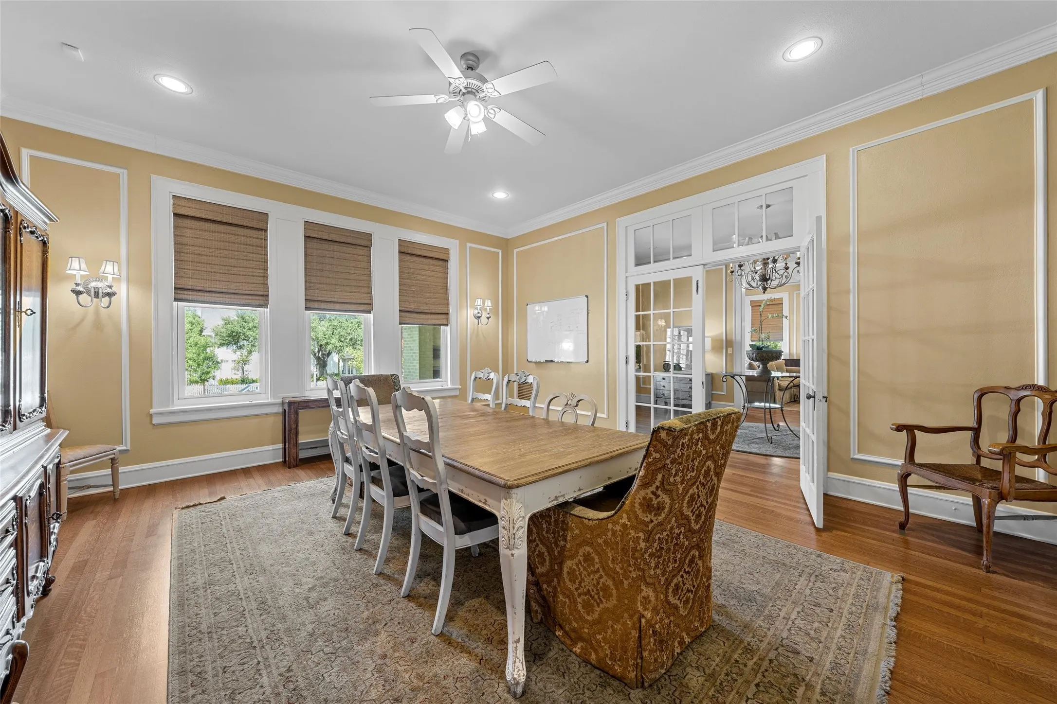 Hardwood flooring, crown molding, recessed lighting, ceiling fan, and French doors