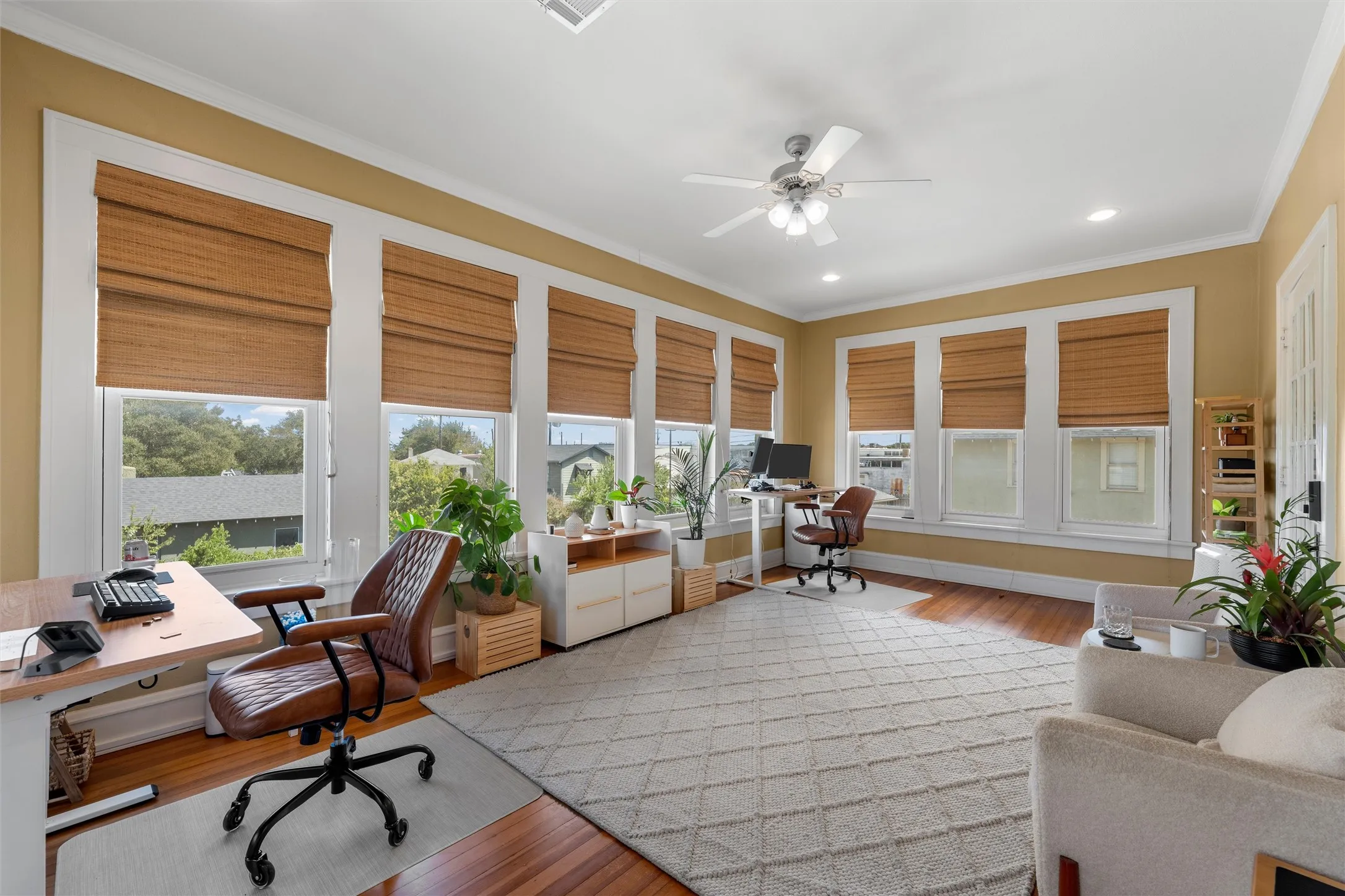 Hardwood flooring, crown molding, abundant natural light, ceiling fan, and recessed lighting