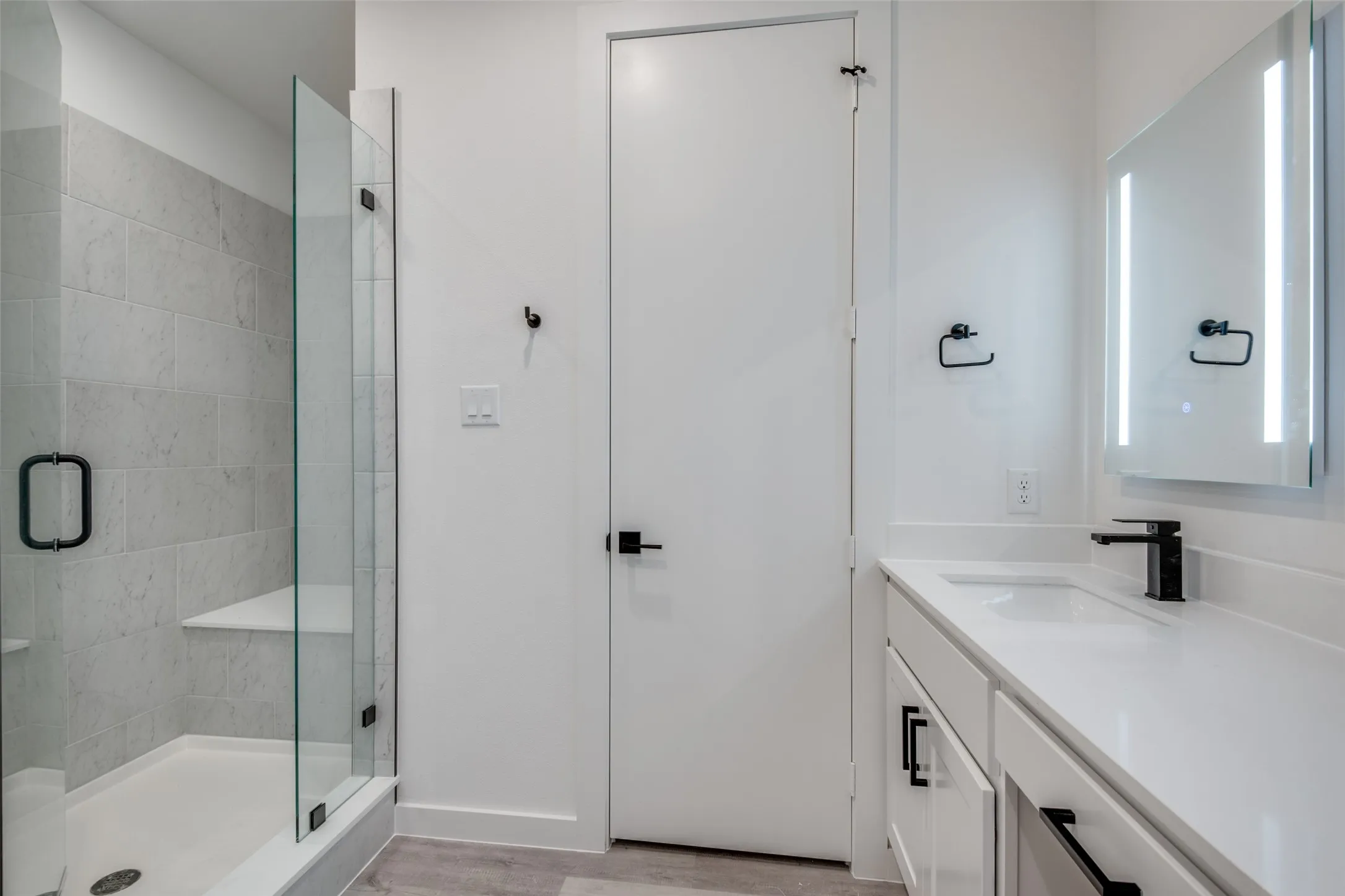 Bathroom with hardwood / wood-style floors, vanity, and a shower with shower door