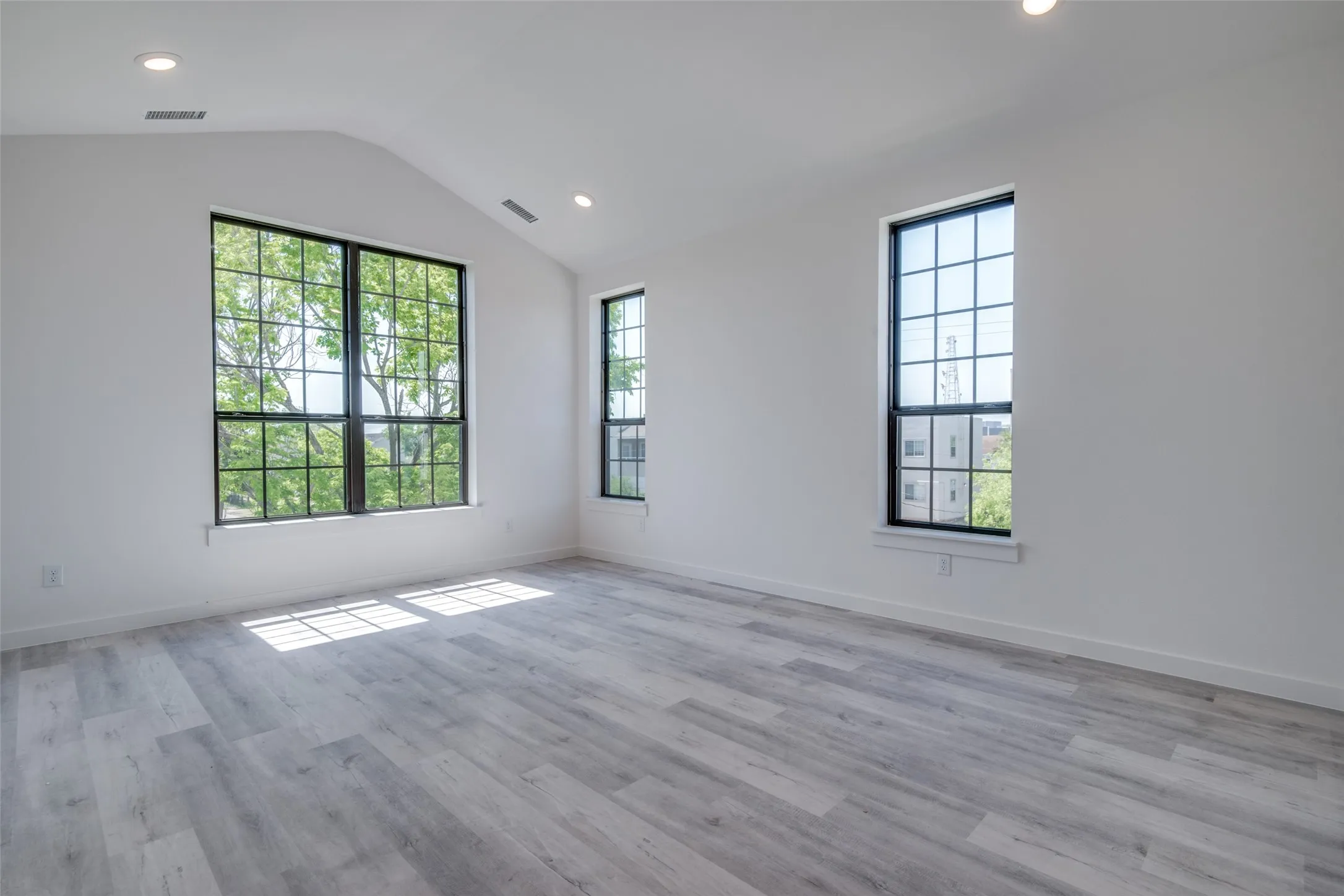 Spare room featuring vaulted ceiling and light hardwood / wood-style flooring