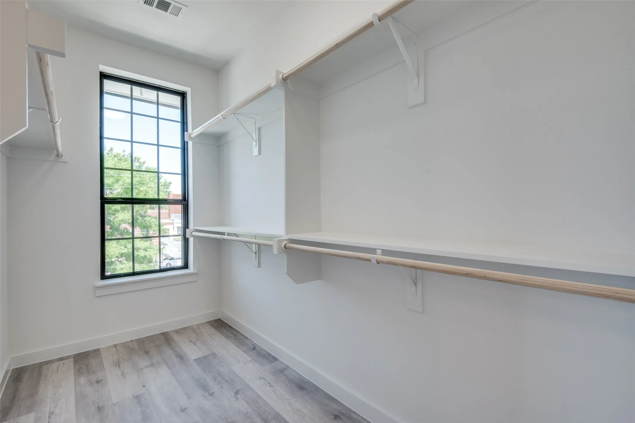 Spacious closet with light hardwood / wood-style flooring