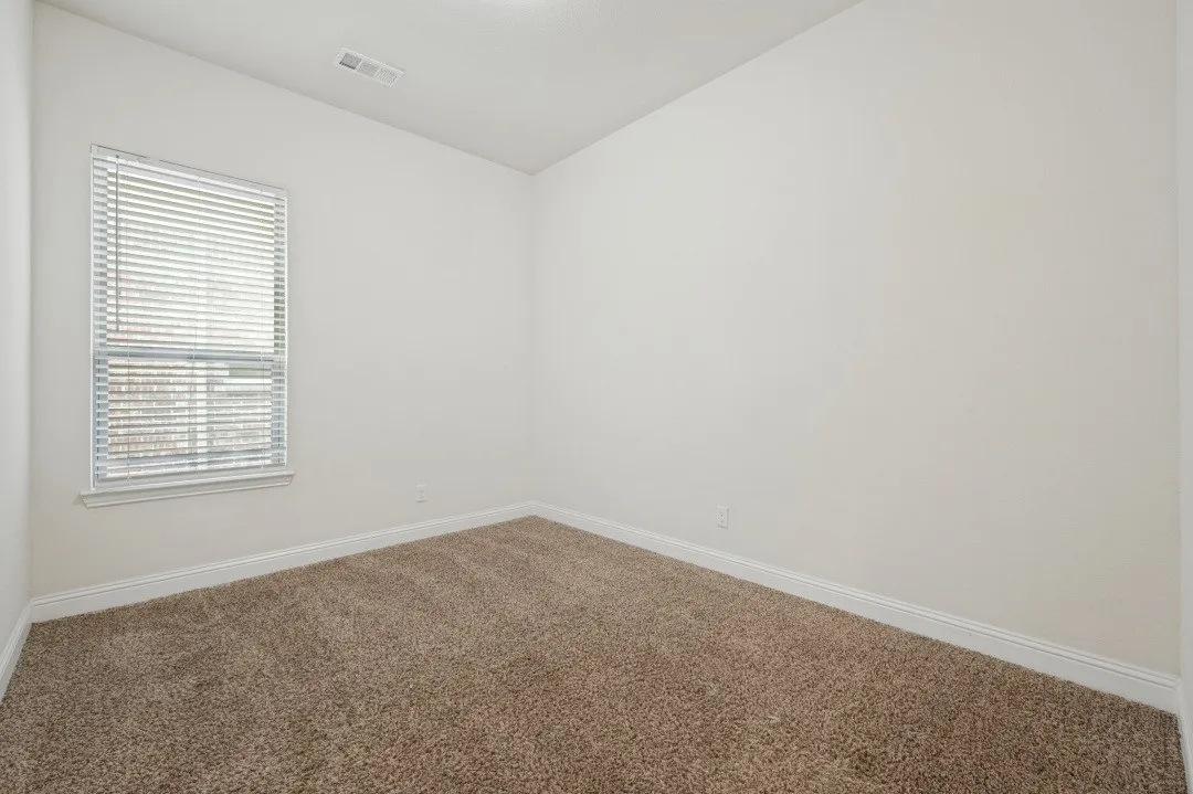 Carpeted flooring, single window with blinds, white walls, and white trim