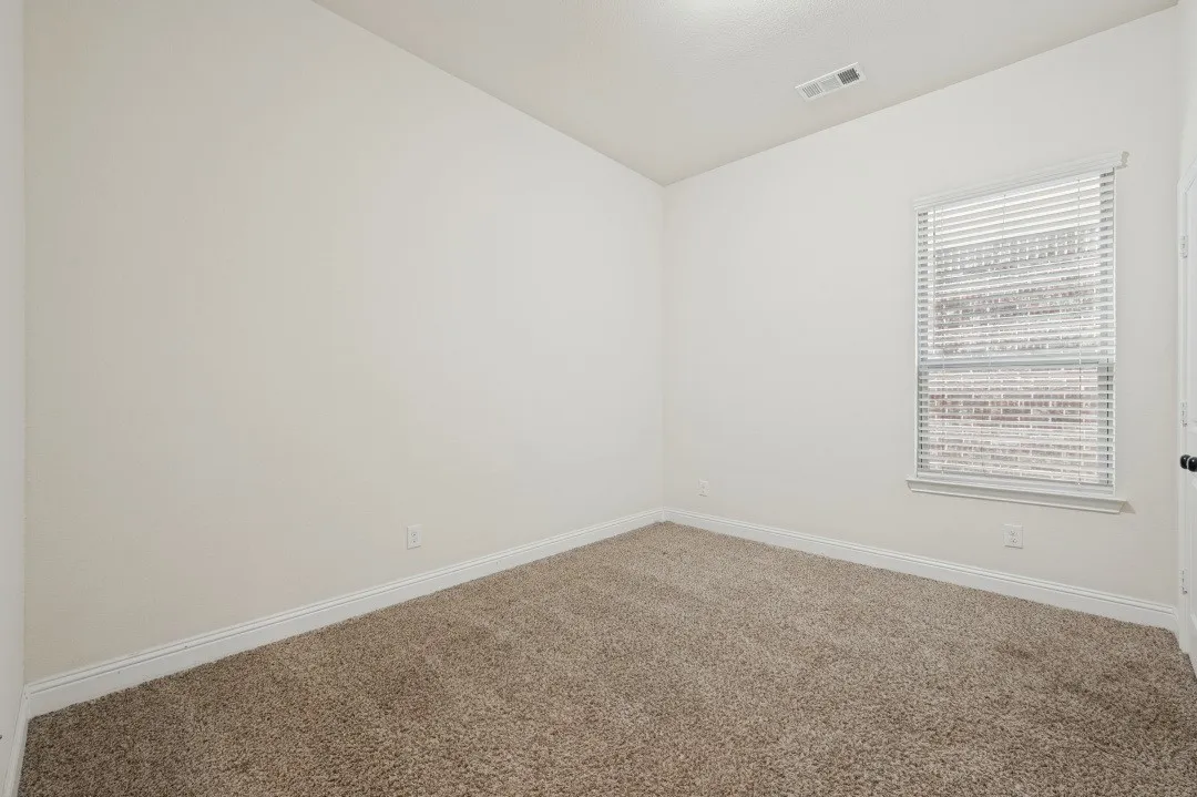 Carpeted room with a window, white walls, and white trim