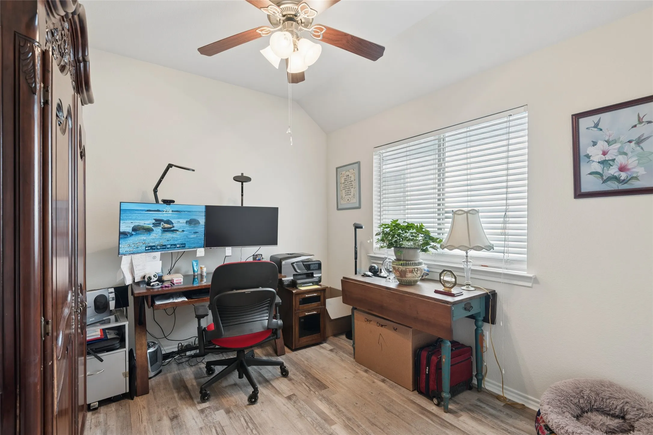 Vaulted ceiling with a ceiling fan, wood-finish flooring, and a window with blinds