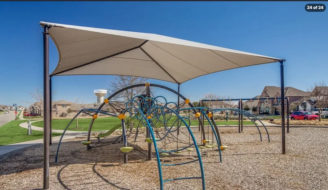 Outdoor play structure with a protective shade canopy and wood chip surfacing