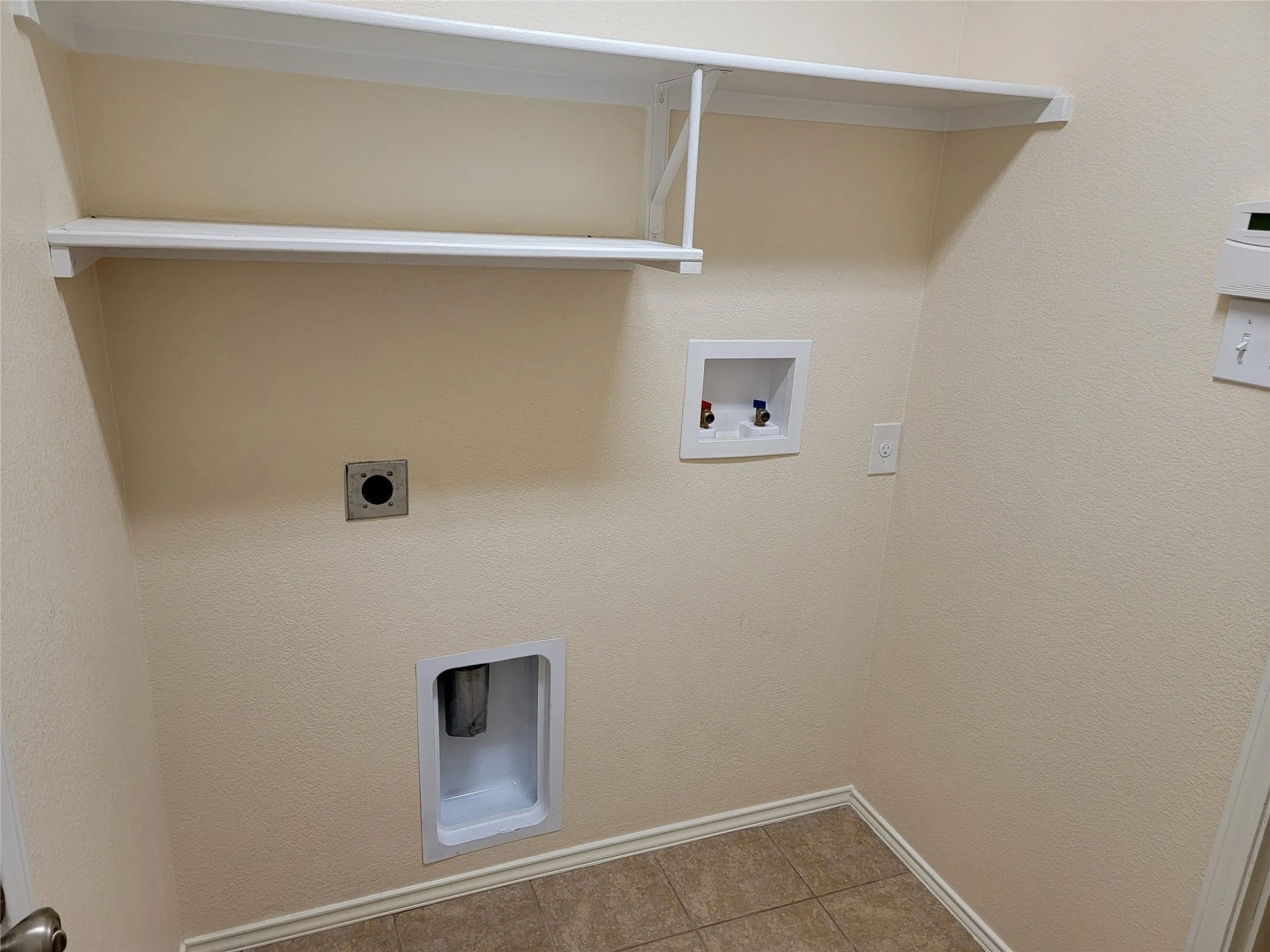 Separate utility room near garage has built-in shelves and space for your full-size washer and dryer.