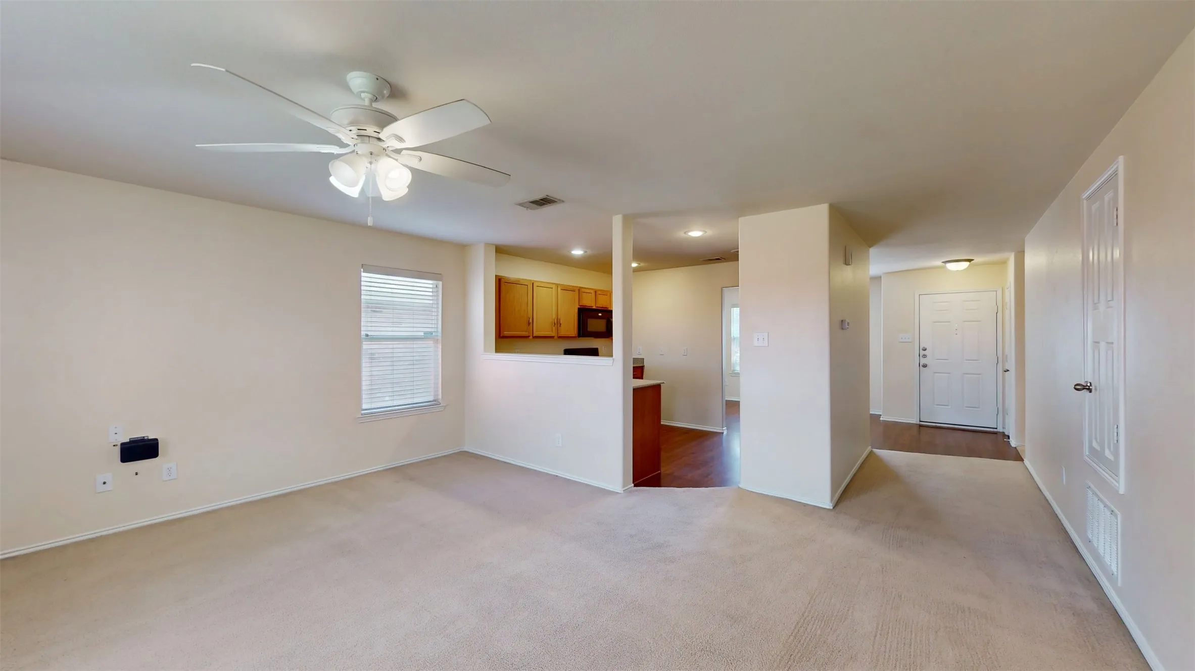 Living open to kitchen with a view to the front entry door.