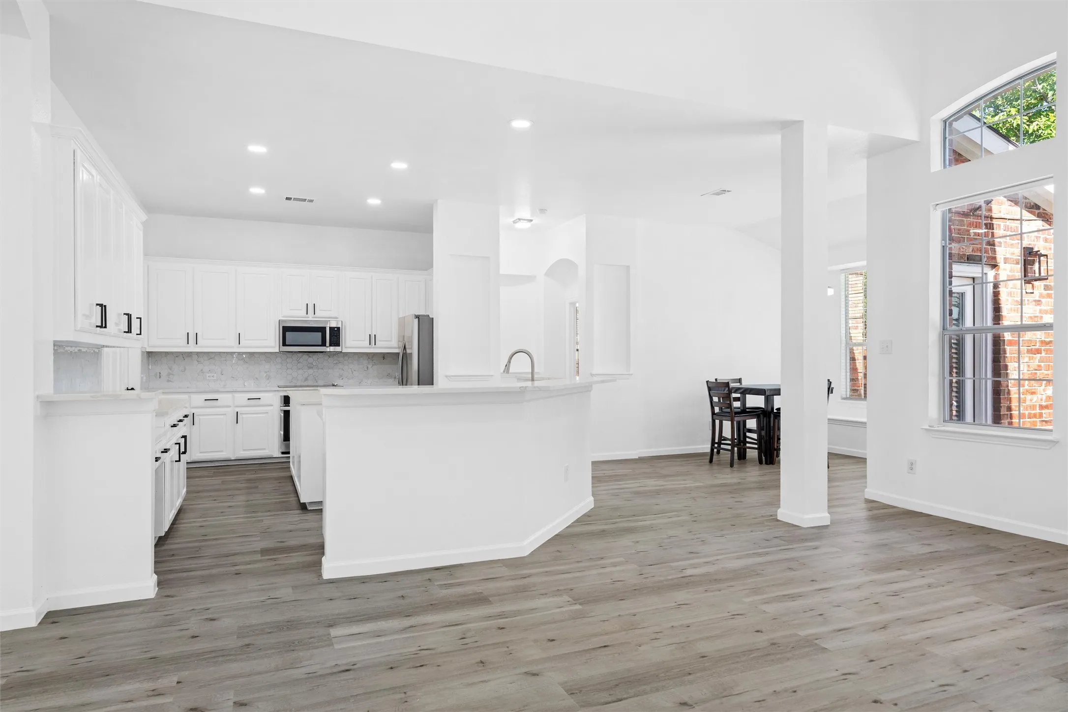 Kitchen featuring white cabinetry, stainless steel appliances, and a breakfast bar