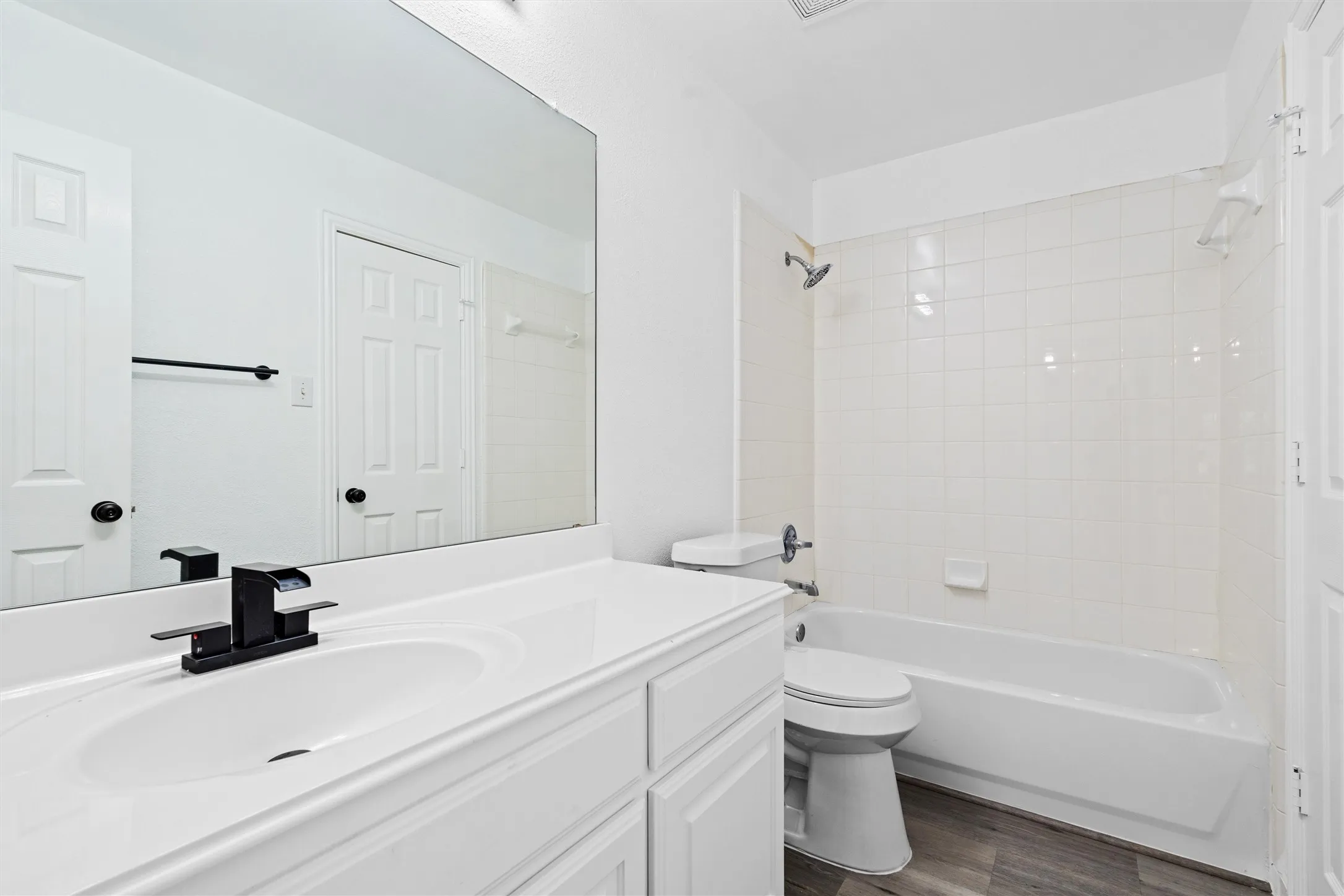 White vanity with an integrated sink and black faucet