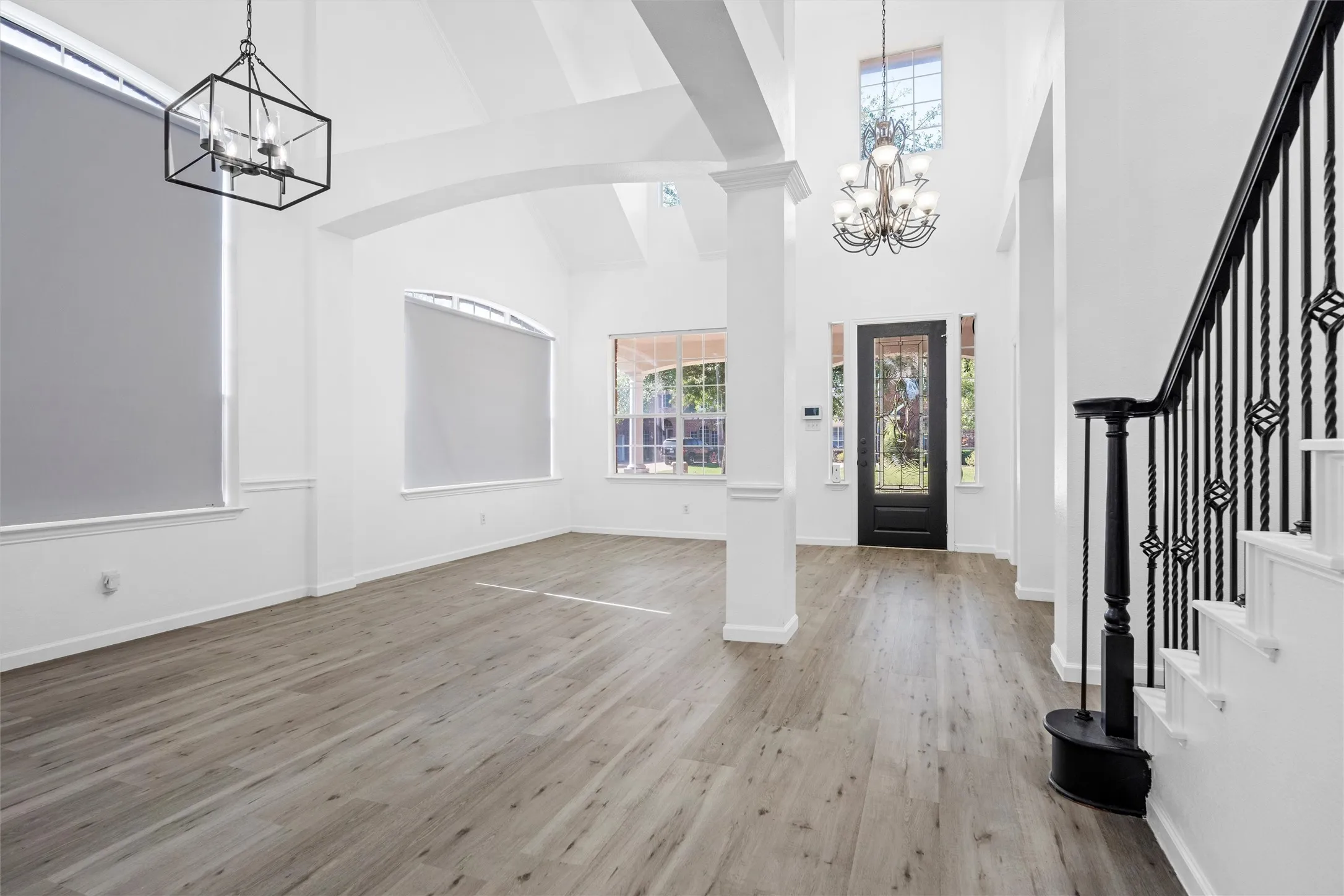 Vaulted ceilings, wood-finish flooring, and arched doorways define this interior