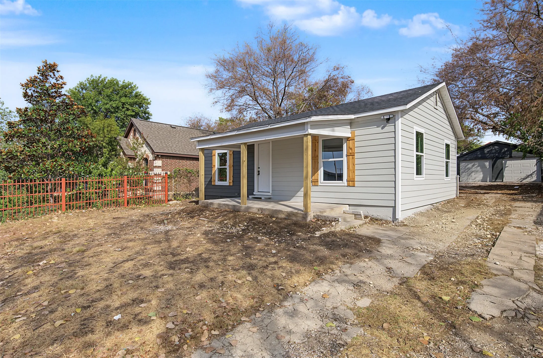 Light gray exterior siding with wood-finish window accents