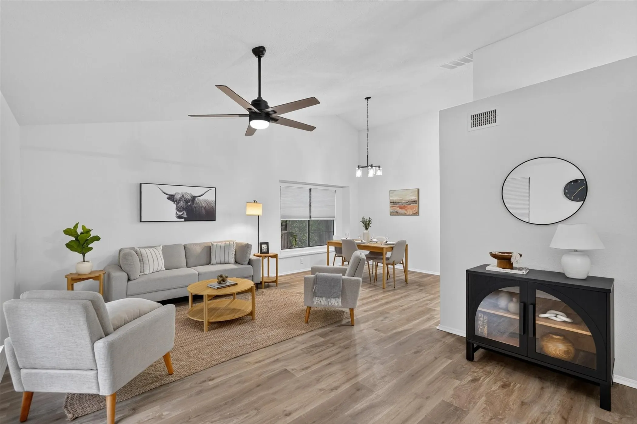 Vaulted ceilings enhance the open-concept living space, featuring wood-finish flooring throughout