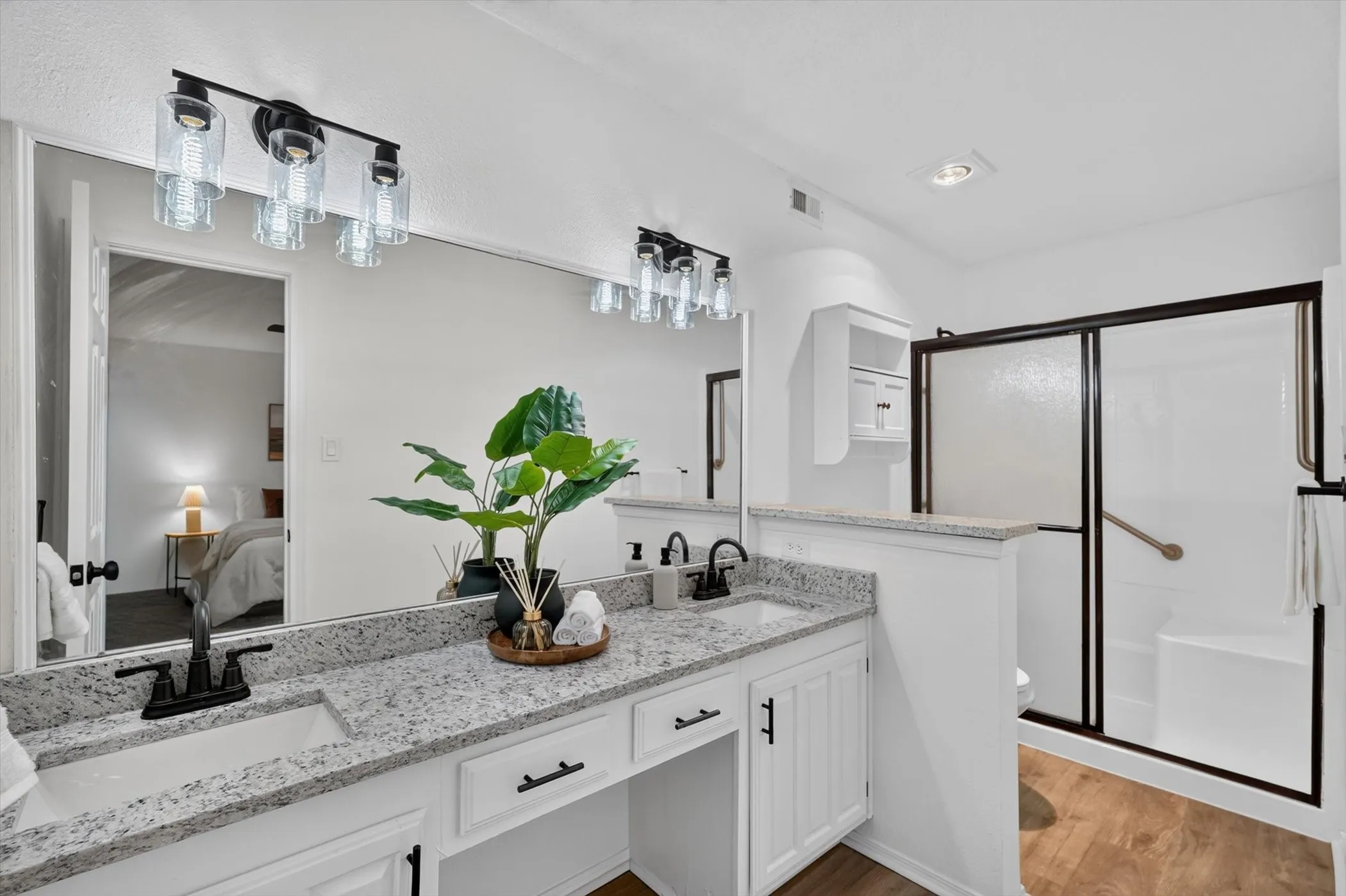 Dual vanity with speckled countertops, dual undermount sinks, and matte black fixtures