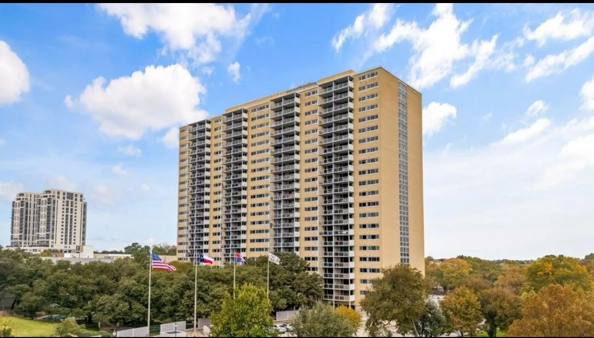High-rise building with a light-colored exterior and multiple balconies