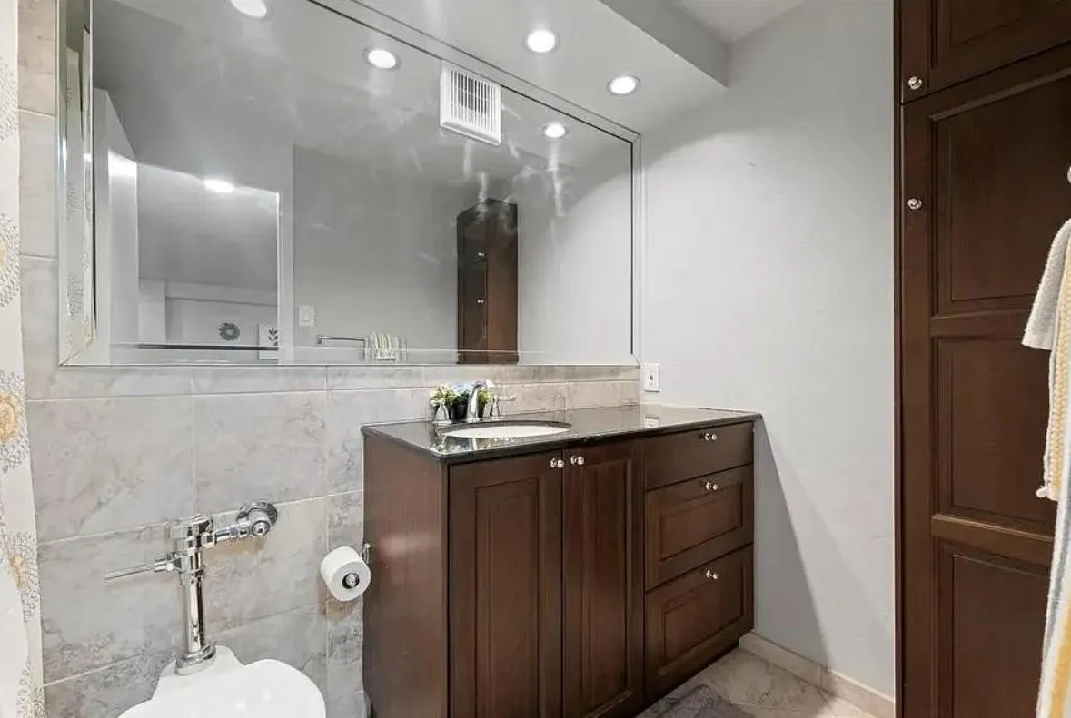 Dark wood finish vanity with an integrated sink and dark countertop