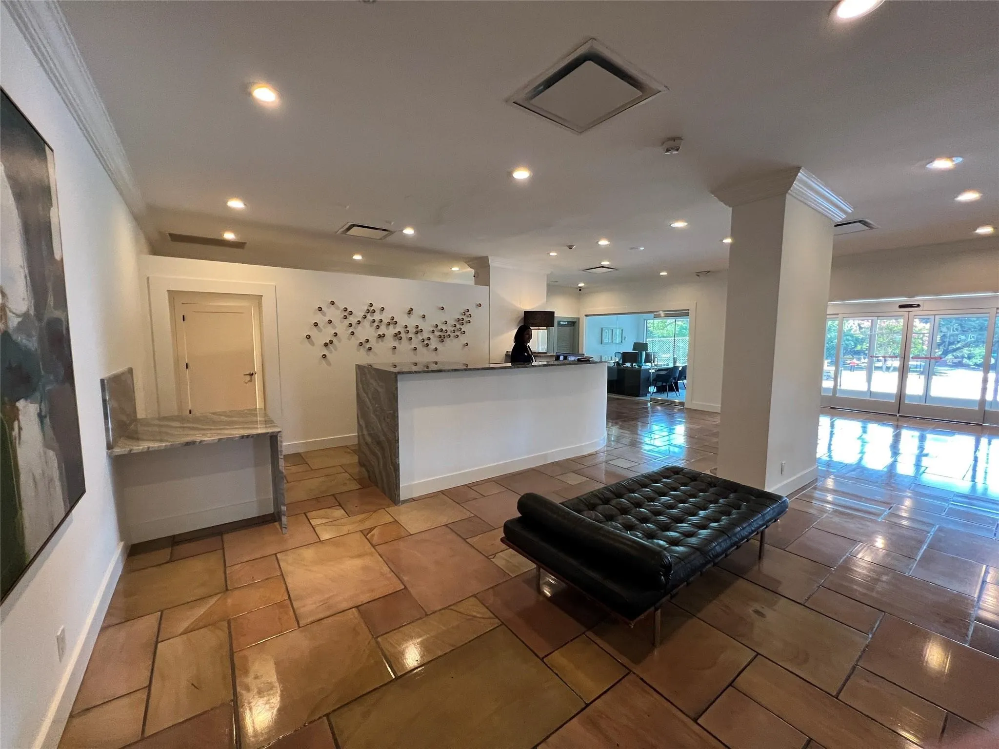 Polished natural stone tile flooring, recessed lighting, crown molding, and granite-finish countertop