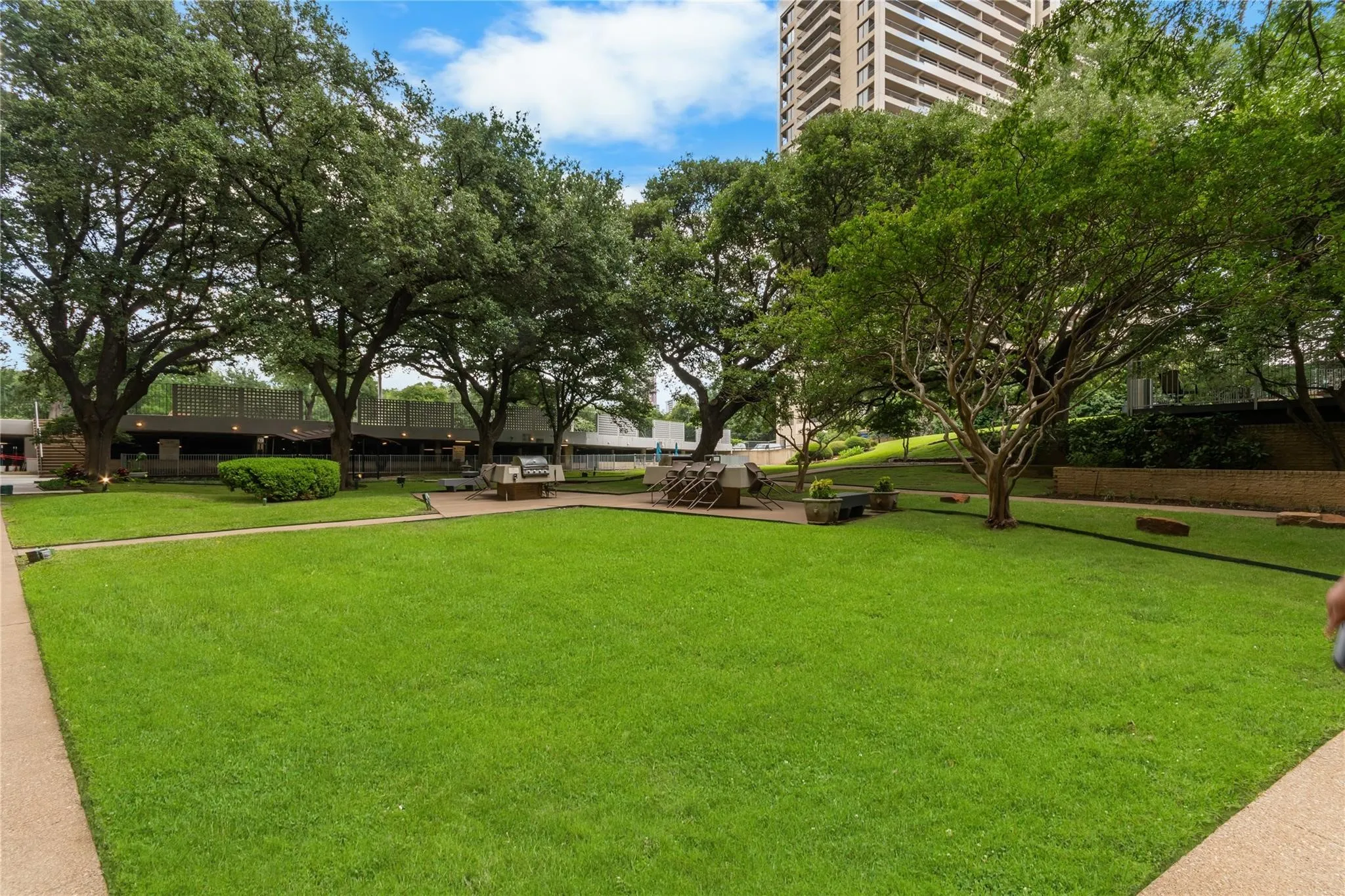 Manicured lawn area with mature trees and paved pathways