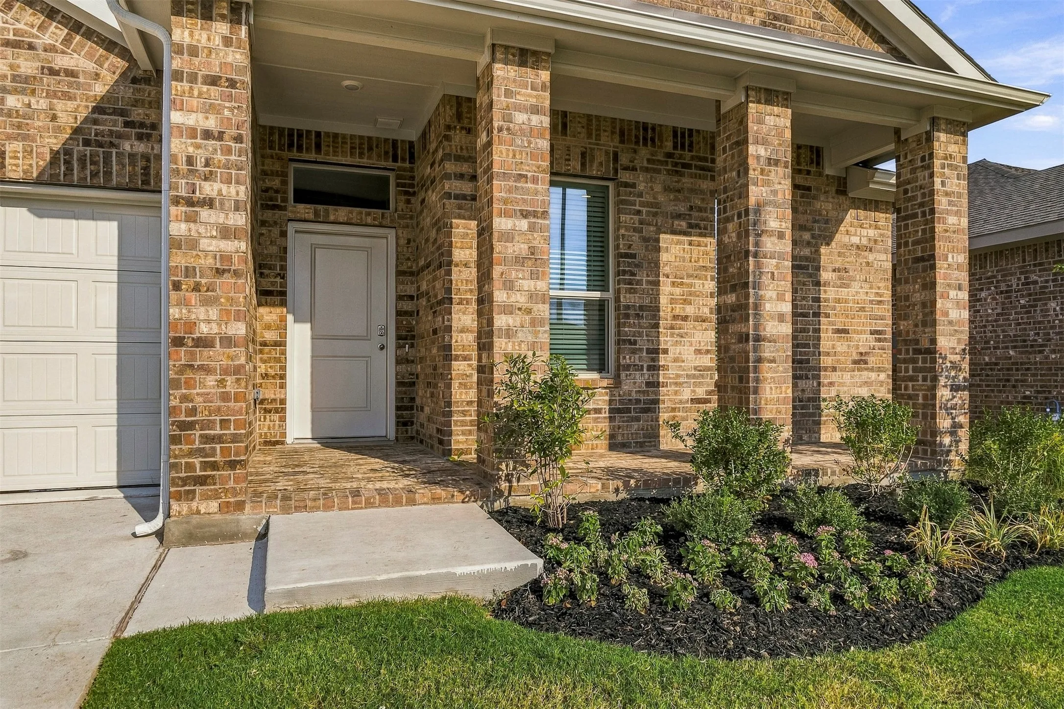 Brick exterior featuring a covered entry.