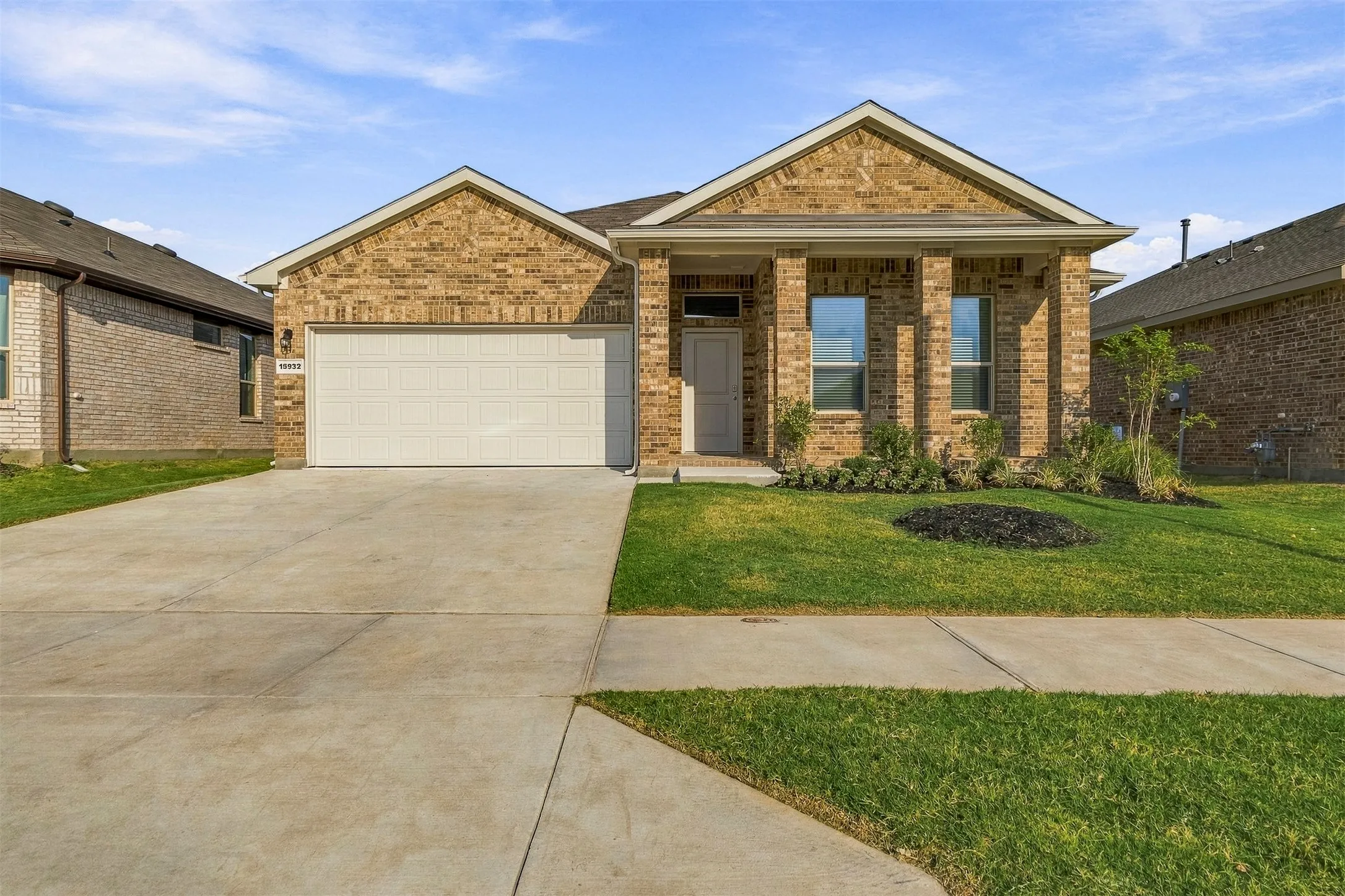 Brick exterior with gabled roof lines, an attached two-car garage, and a covered porch entry.