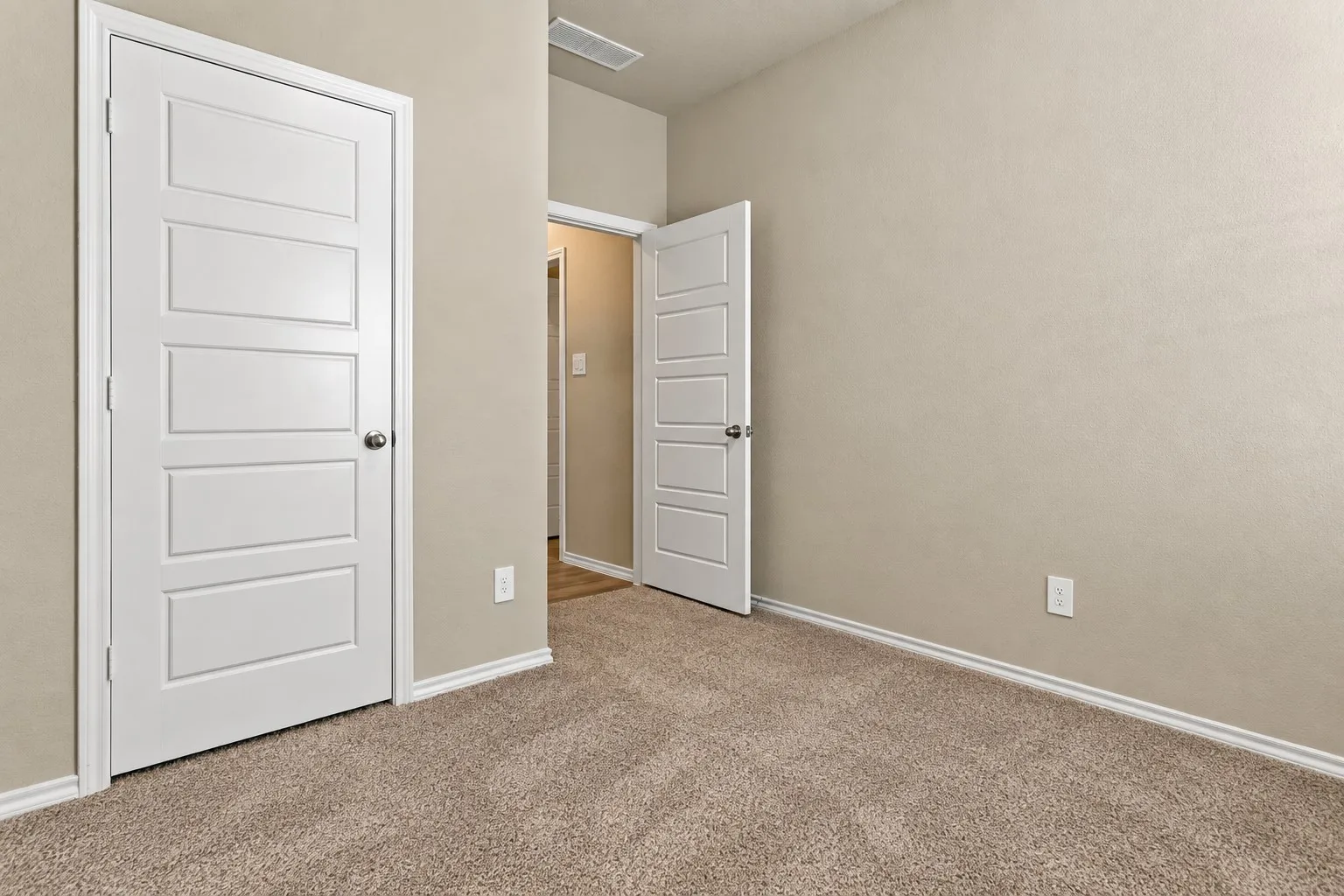 Neutral wall color, carpeted flooring, white trim, and white panel doors