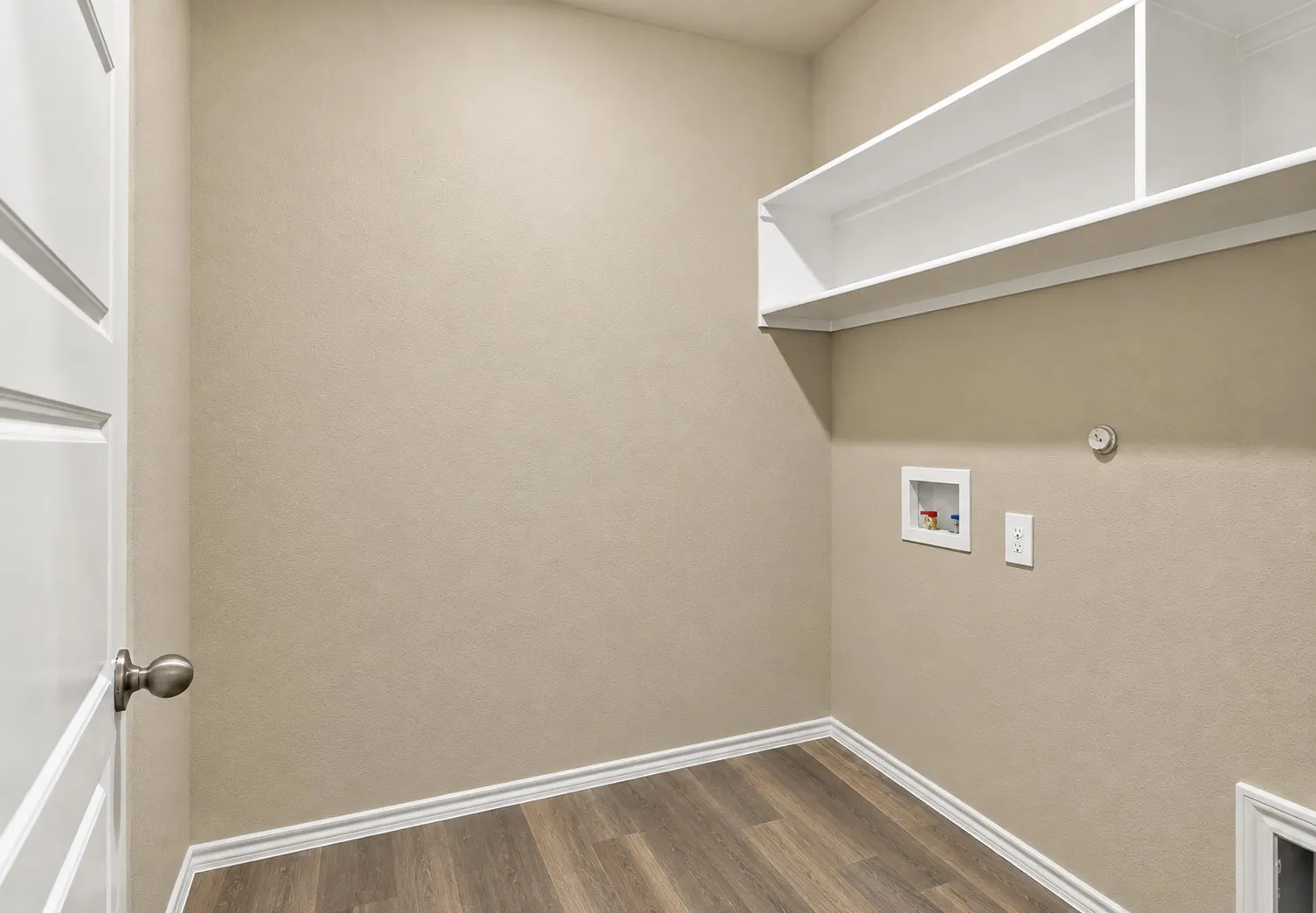 Laundry area featuring wood-finish flooring, built-in shelving, and utility hookups