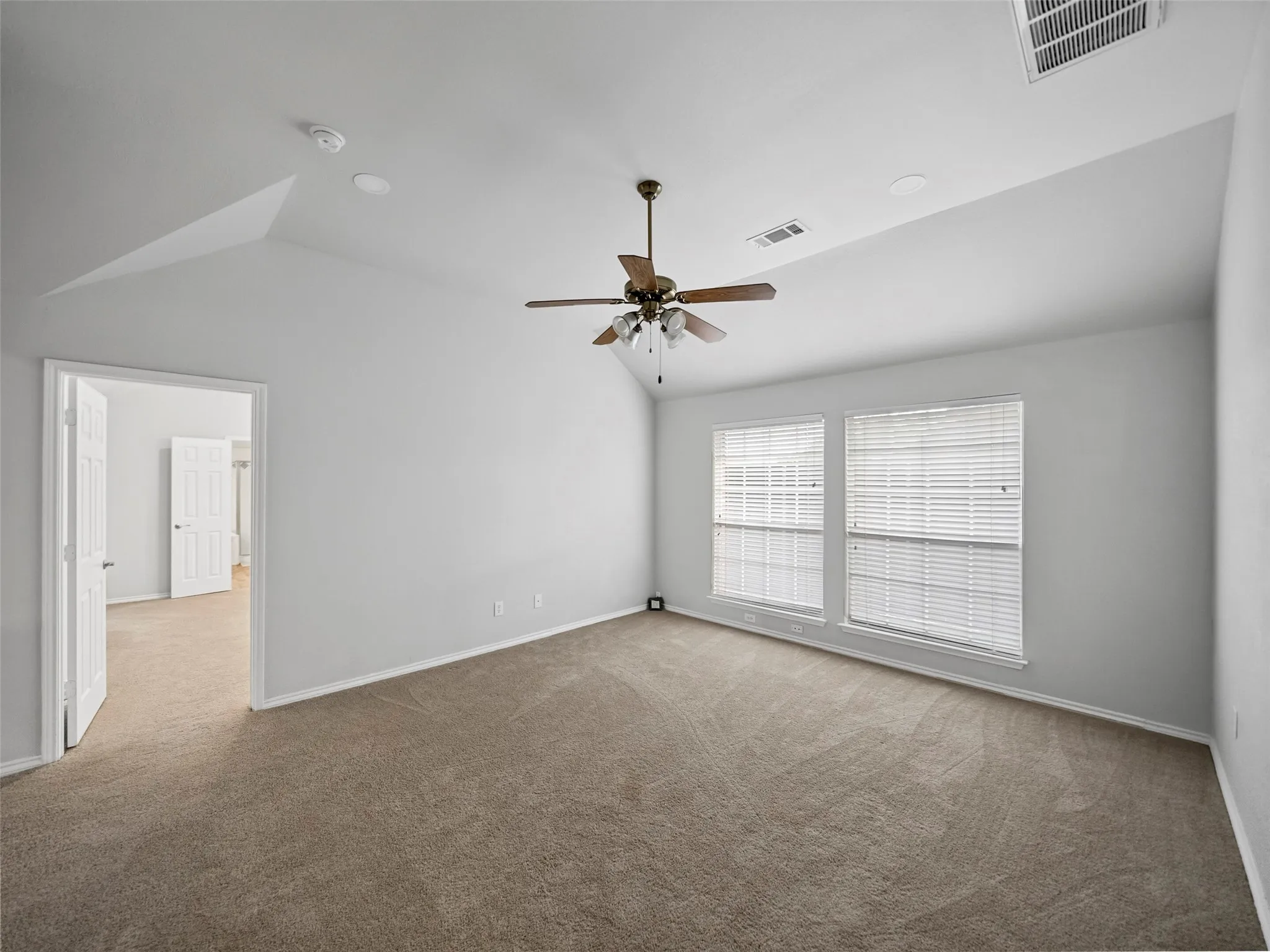 Vaulted ceilings with a ceiling fan, dual windows with blinds, recessed lighting, and soft carpeting