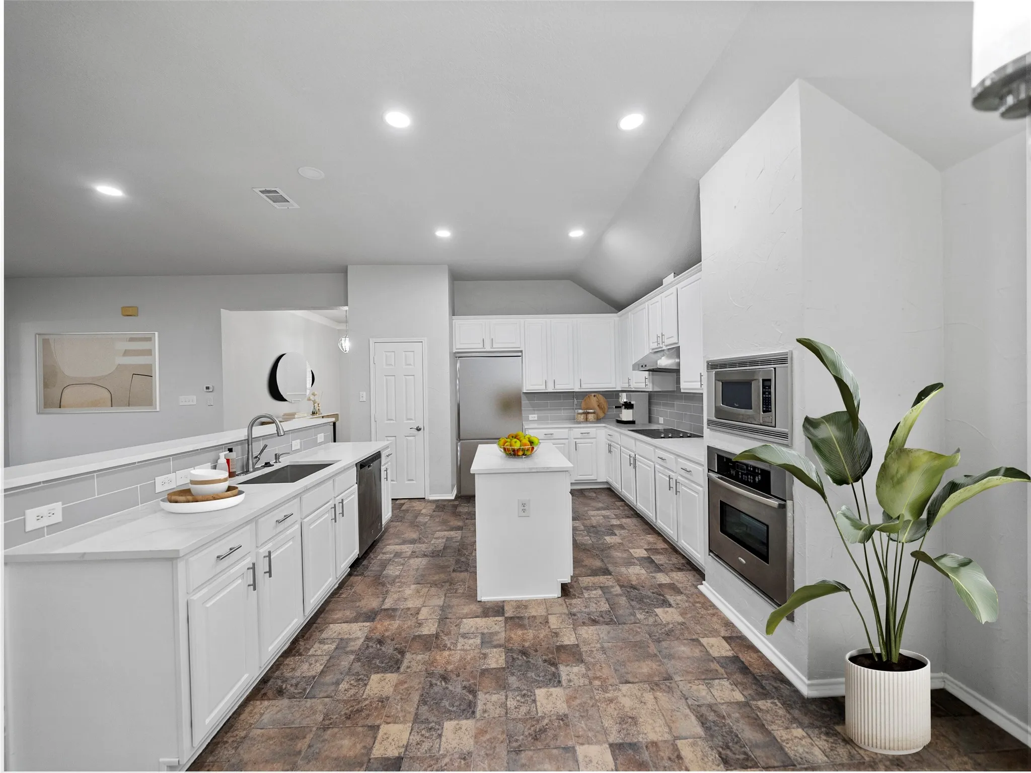 Spacious kitchen with wood-finish flooring, white cabinetry, a center island, and stainless-steel appliances including a built-in microwave and oven
