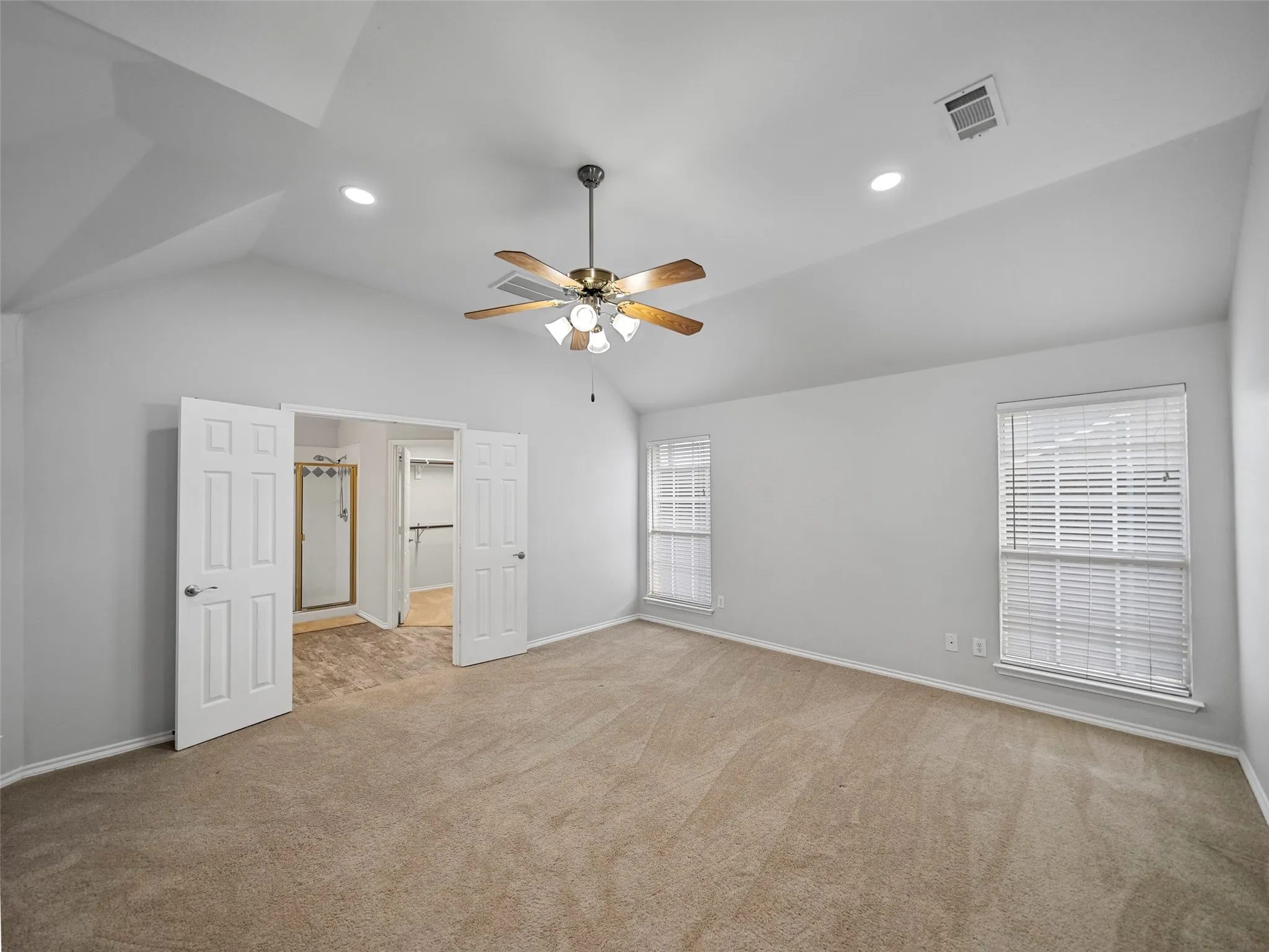 Vaulted ceiling with recessed lighting and ceiling fan