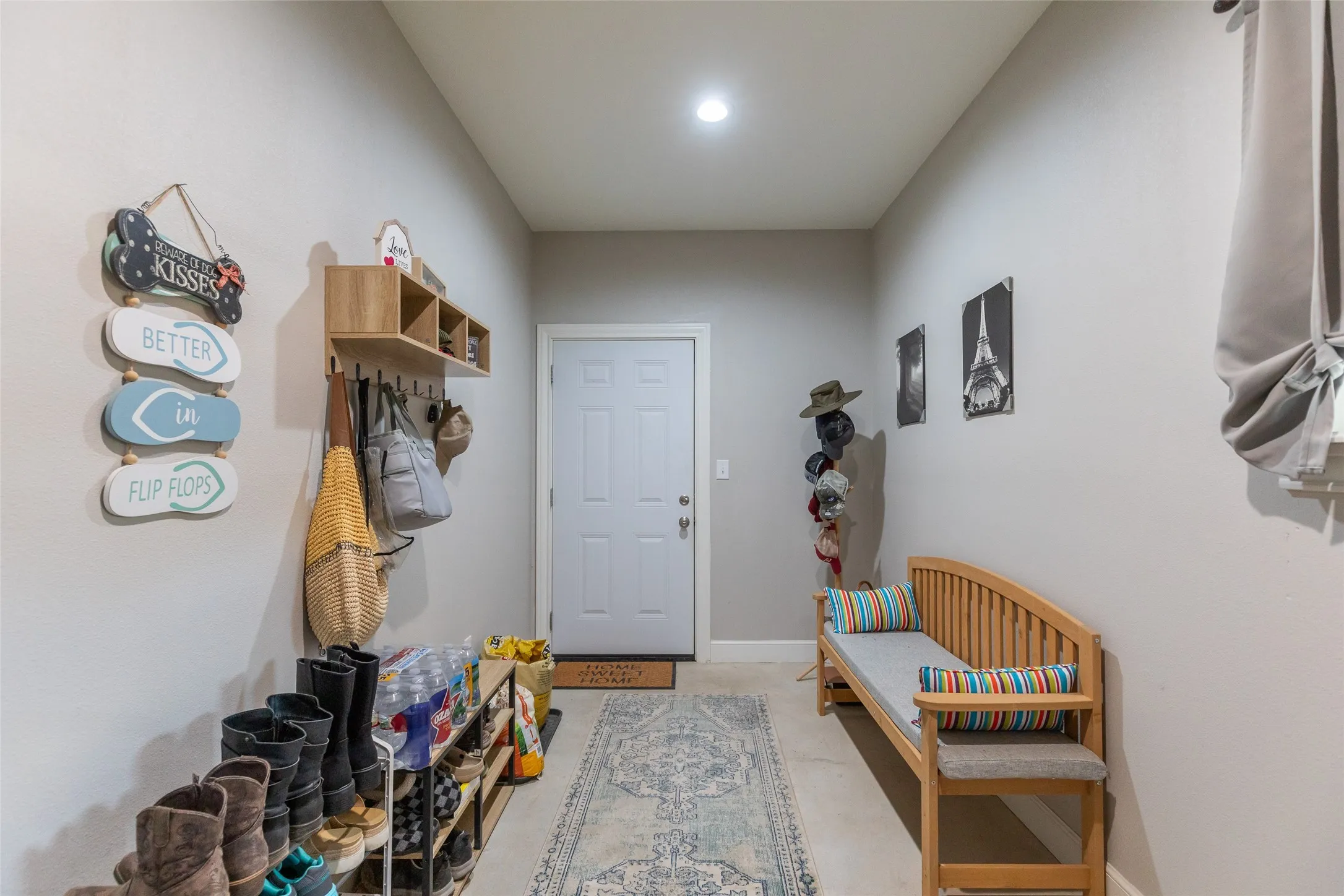 Recessed lighting illuminates the hallway, featuring light-toned walls and a white door