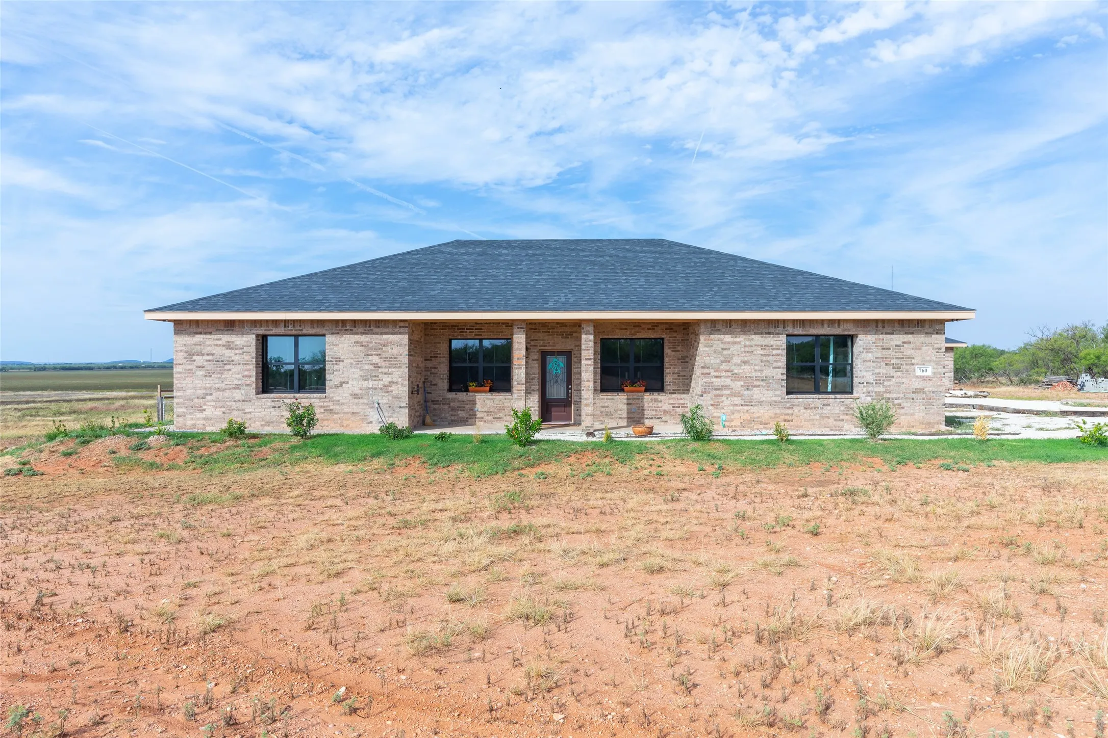 Exterior brick facade with a dark shingle roof and black-framed windows