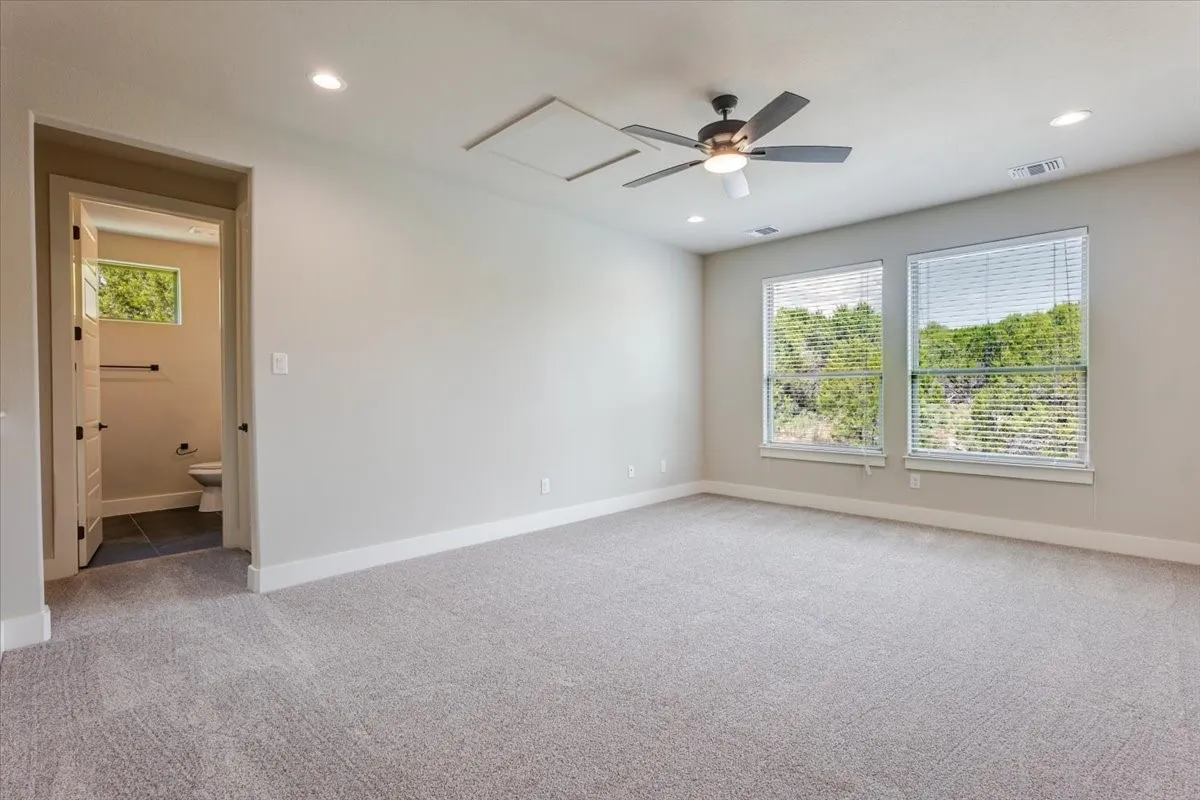 Carpeted room featuring two windows, recessed lighting, and a ceiling fan