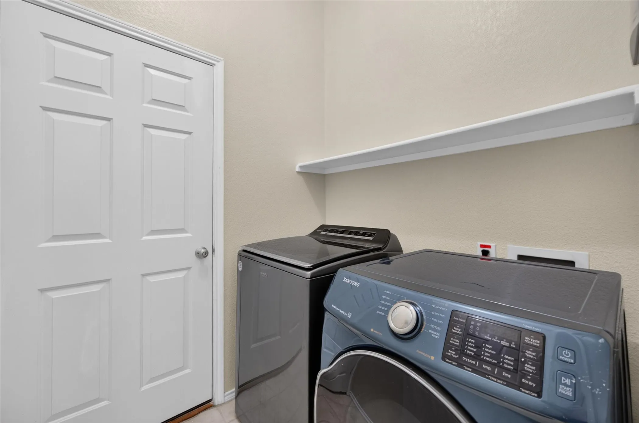 Utility space featuring a six-panel door and a wall-mounted shelving unit