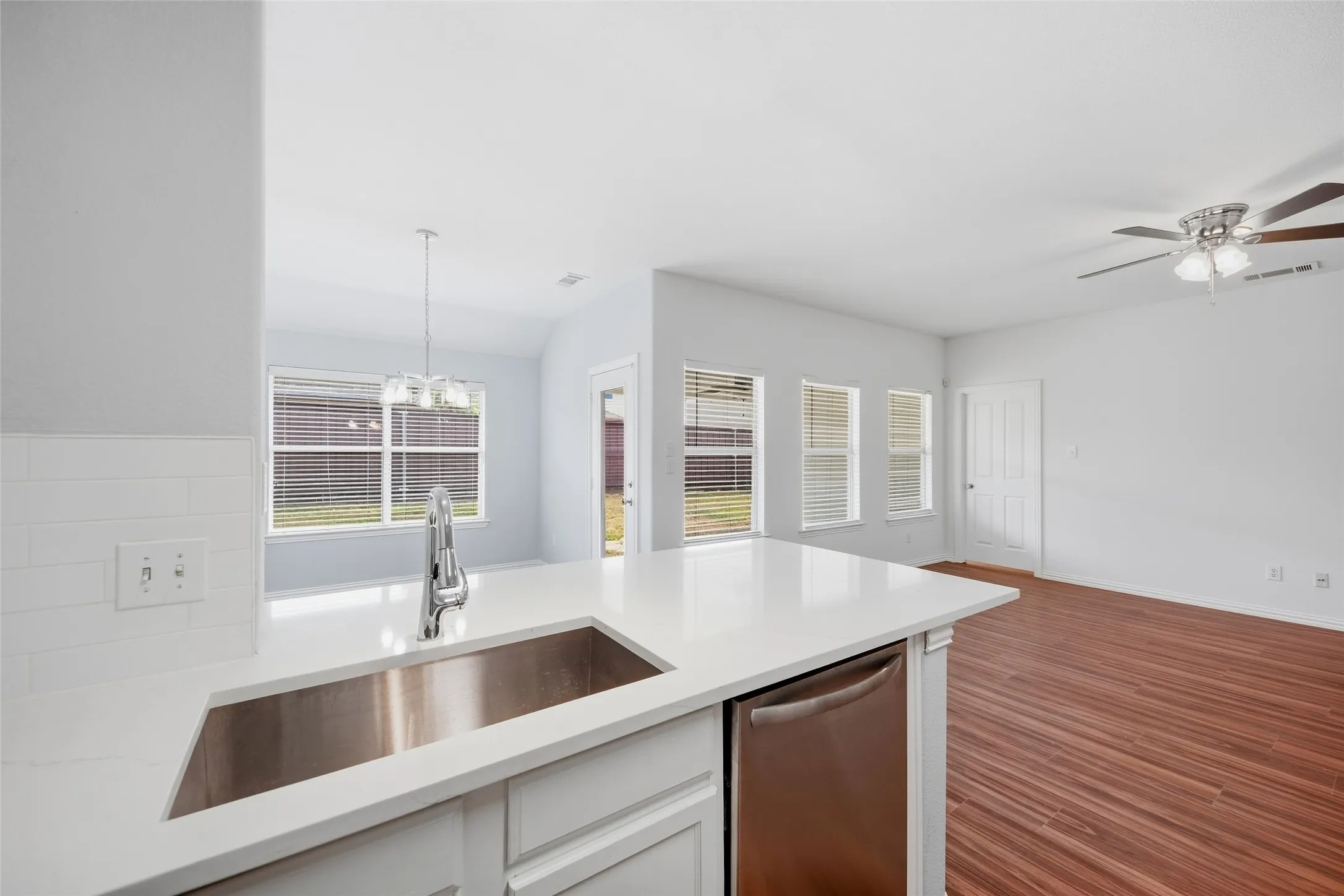The kitchen shines with new quartz countertops and upgraded stainless steel appliances, opening to a welcoming breakfast area where everyday meals and conversations feel right at home.