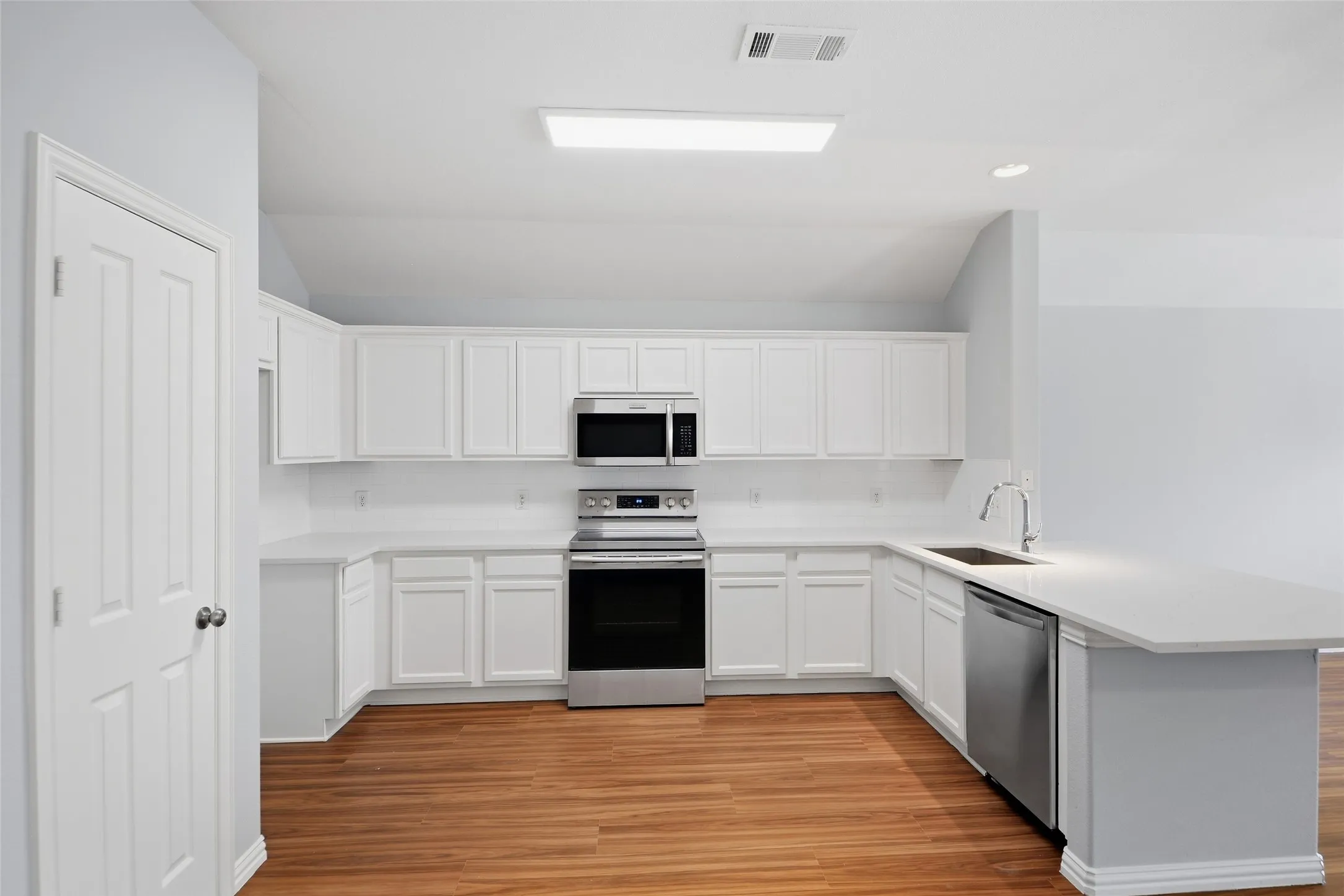 The kitchen shines with new quartz countertops and upgraded stainless steel appliances, opening to a welcoming breakfast area where everyday meals and conversations feel right at home.