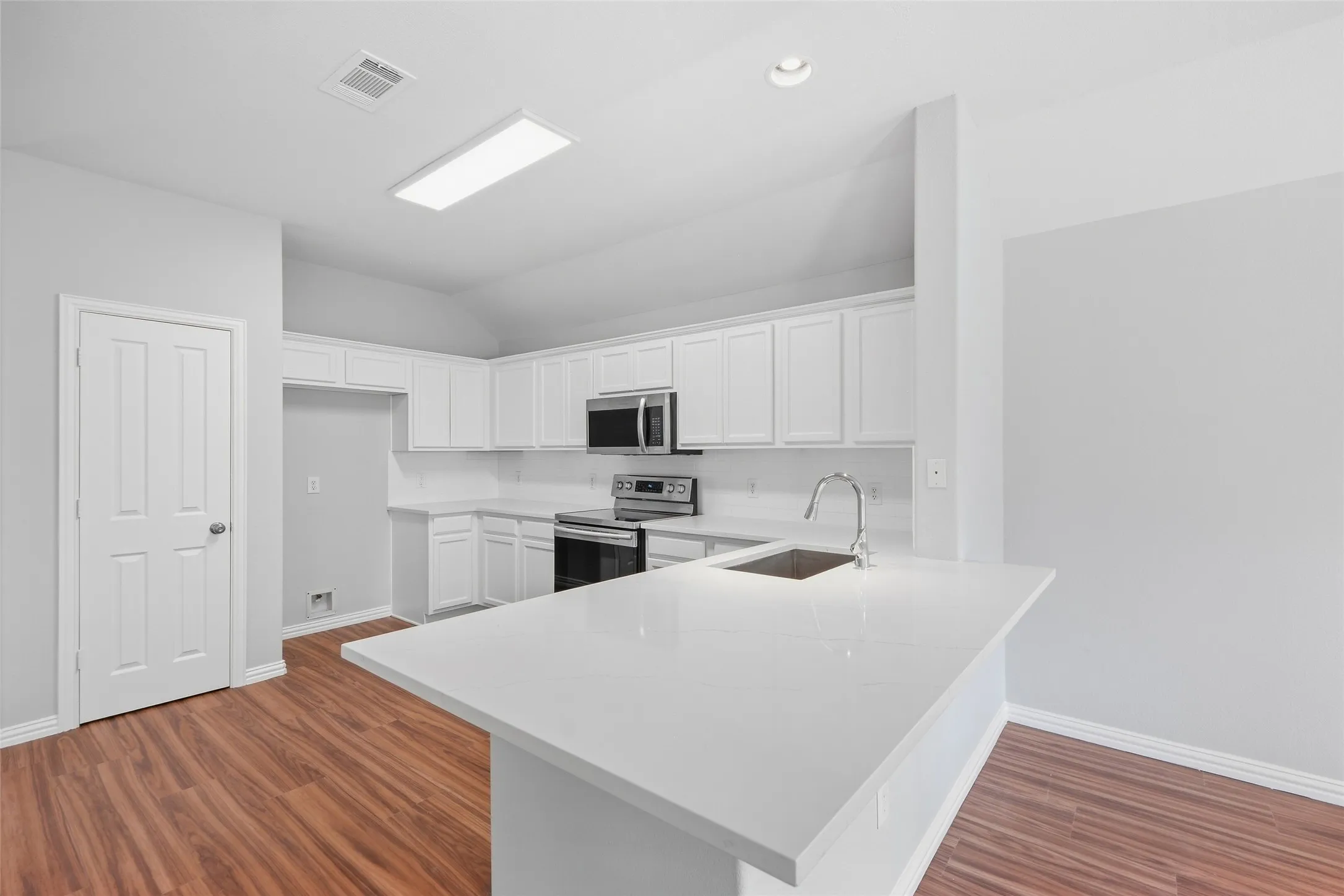 The kitchen shines with new quartz countertops and upgraded stainless steel appliances, opening to a welcoming breakfast area where everyday meals and conversations feel right at home.