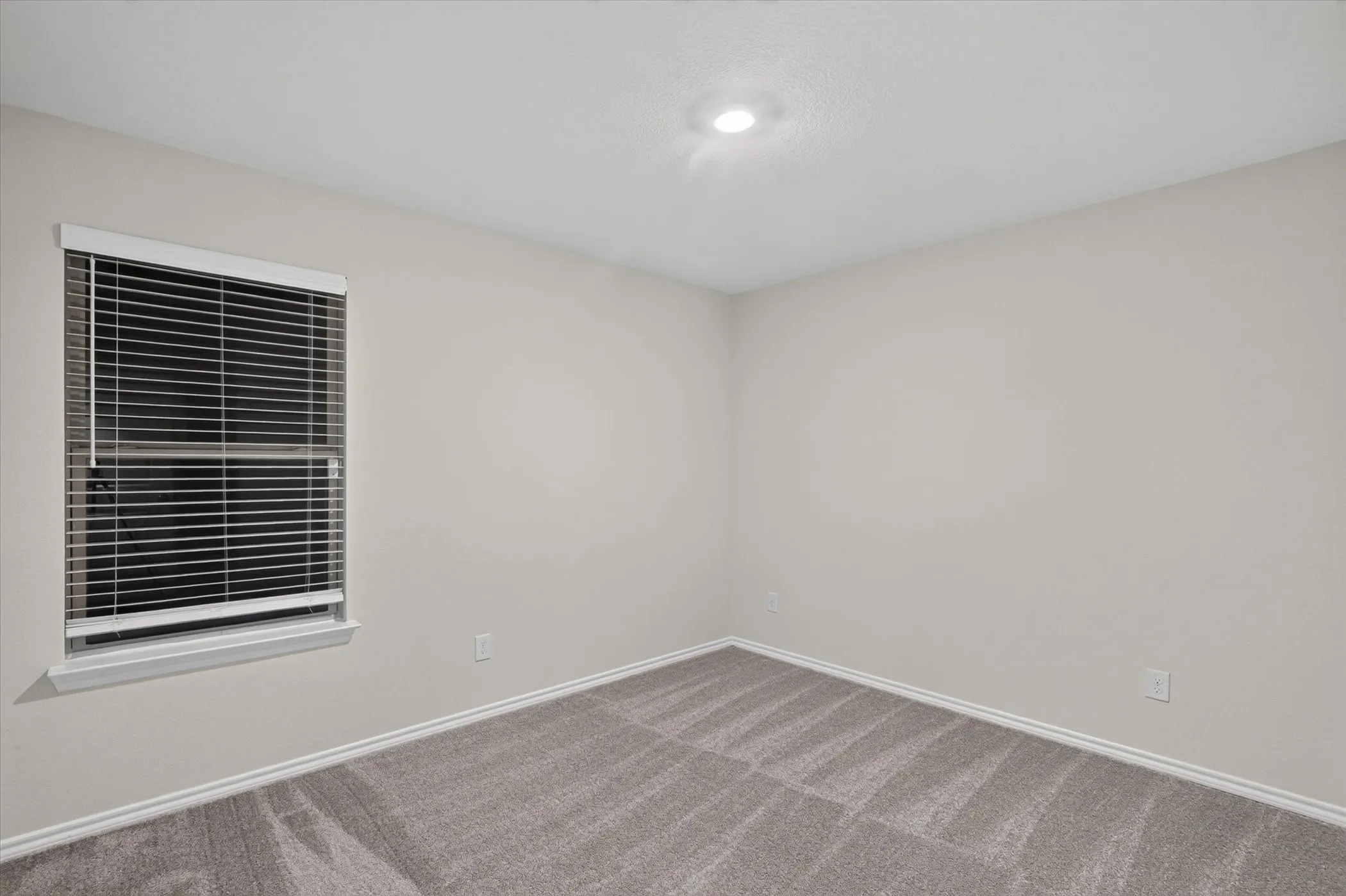 Recessed ceiling lighting, neutral wall paint, window with blinds, and carpeting