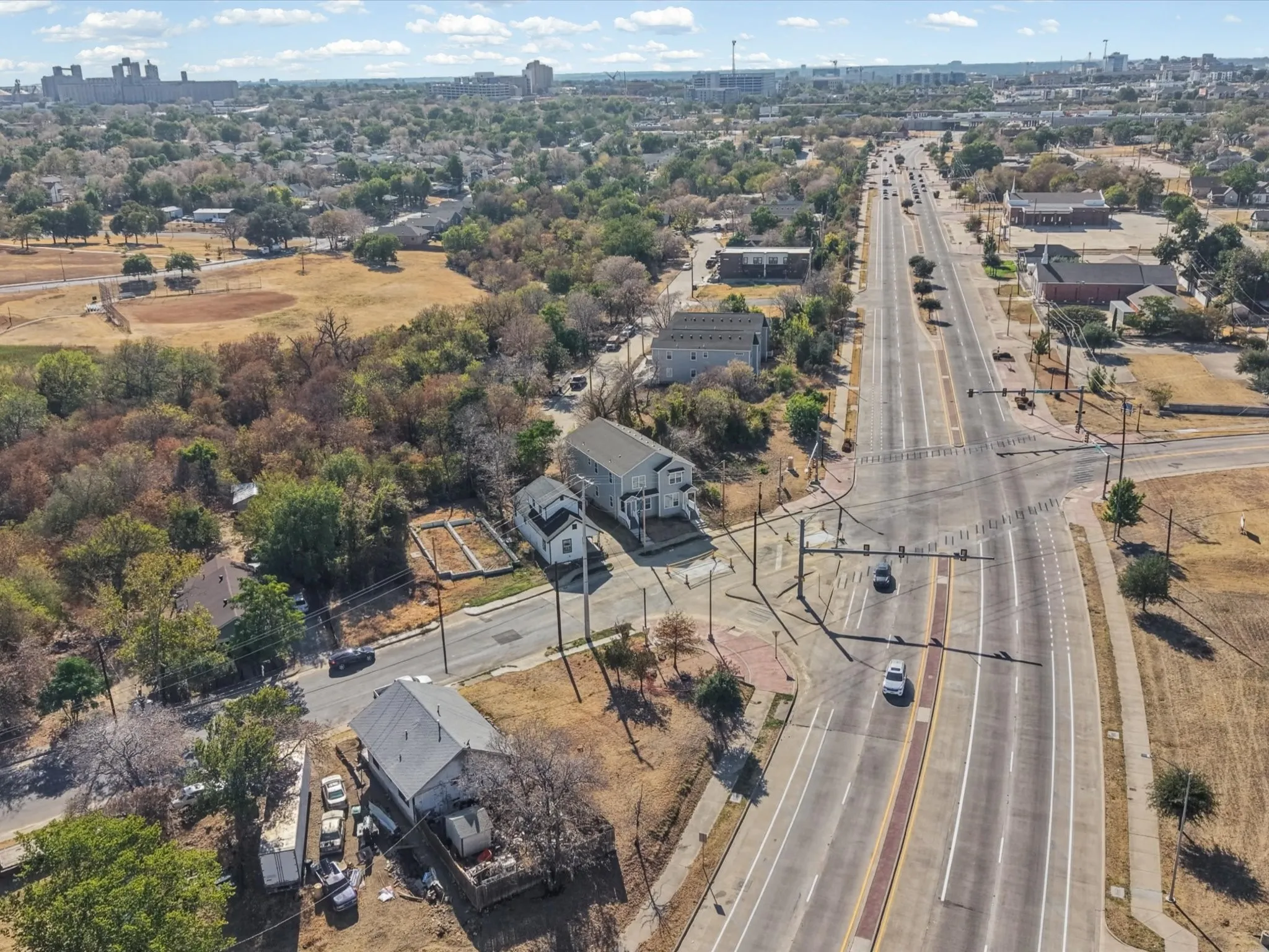 Aerial perspective showcasing a major roadway, urban development, and expansive green spaces