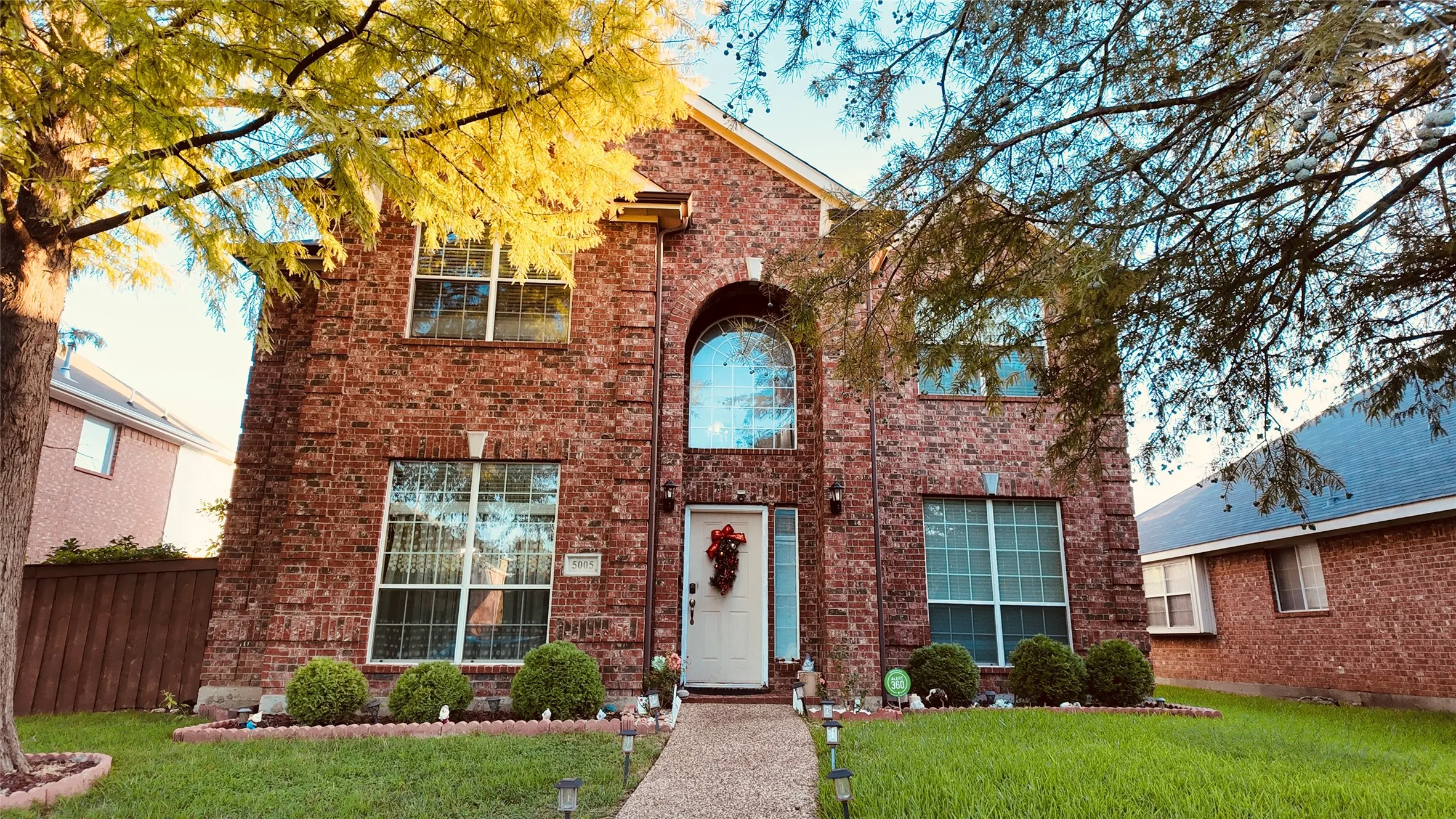 Brick facade featuring a prominent arched window, multiple large windows, and a front pathway