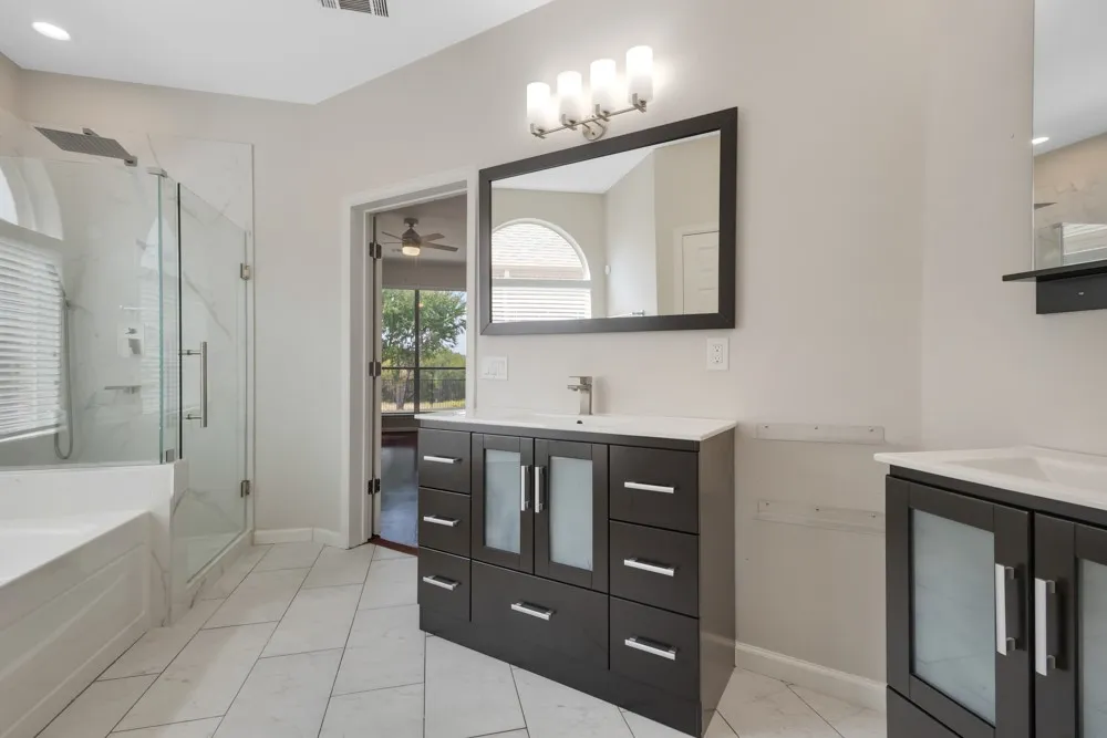 White tile flooring with a large walk-in shower featuring glass enclosure and rain shower head