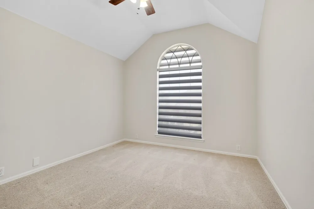 Vaulted ceiling with an arched window, featuring horizontal blinds