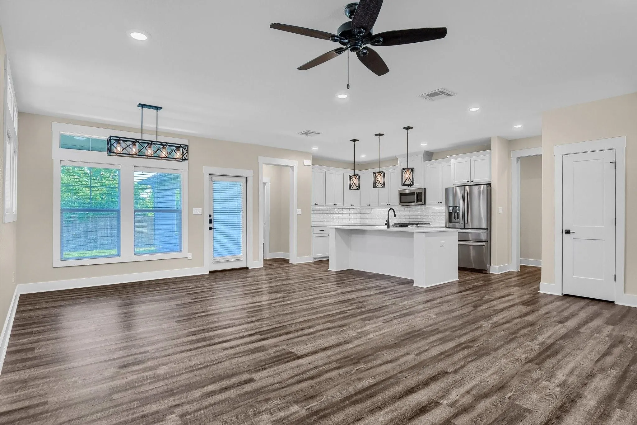 Open-concept living space with wood-finish flooring, recessed lighting, and a ceiling fan