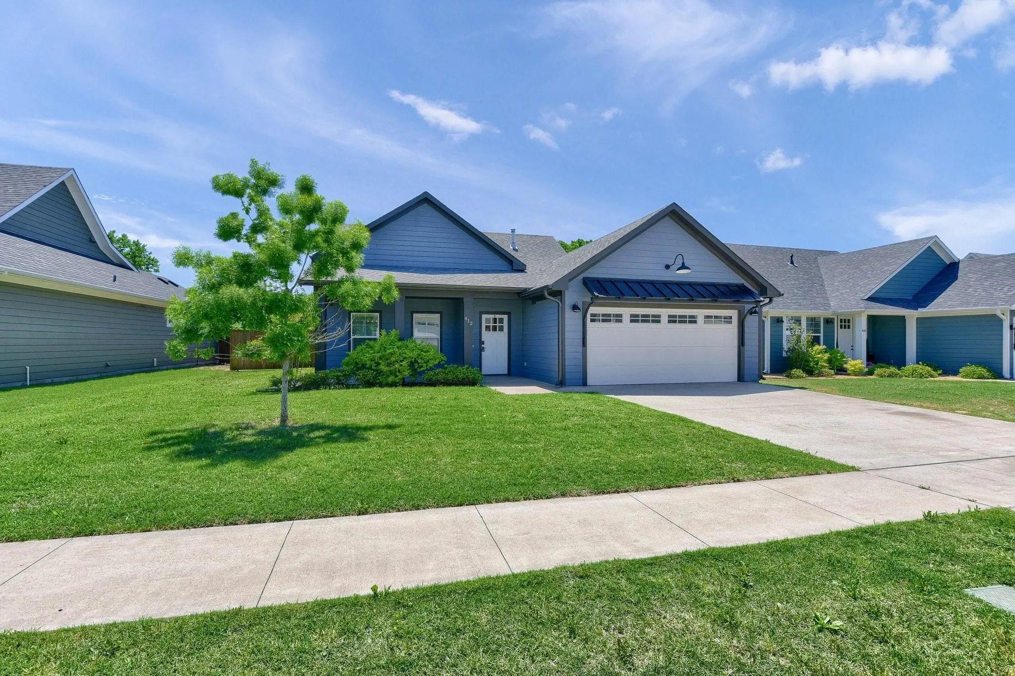 Single-story residence featuring blue siding and a white garage door