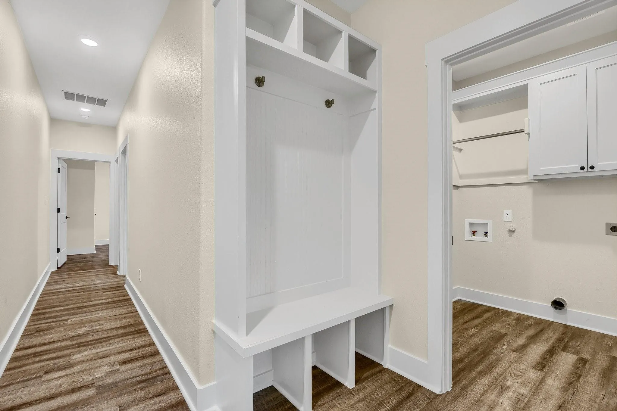 Hallway featuring wood-finish flooring, recessed lighting, and a built-in storage bench with shelving