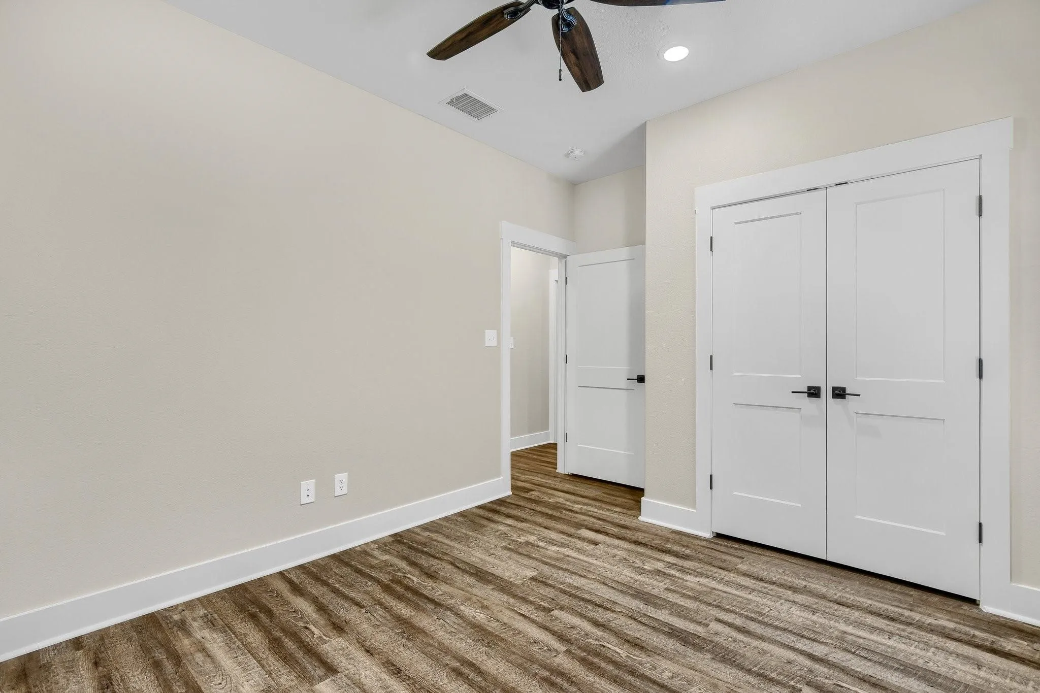 Wood-finish flooring, white trim, recessed lighting, and a ceiling fan