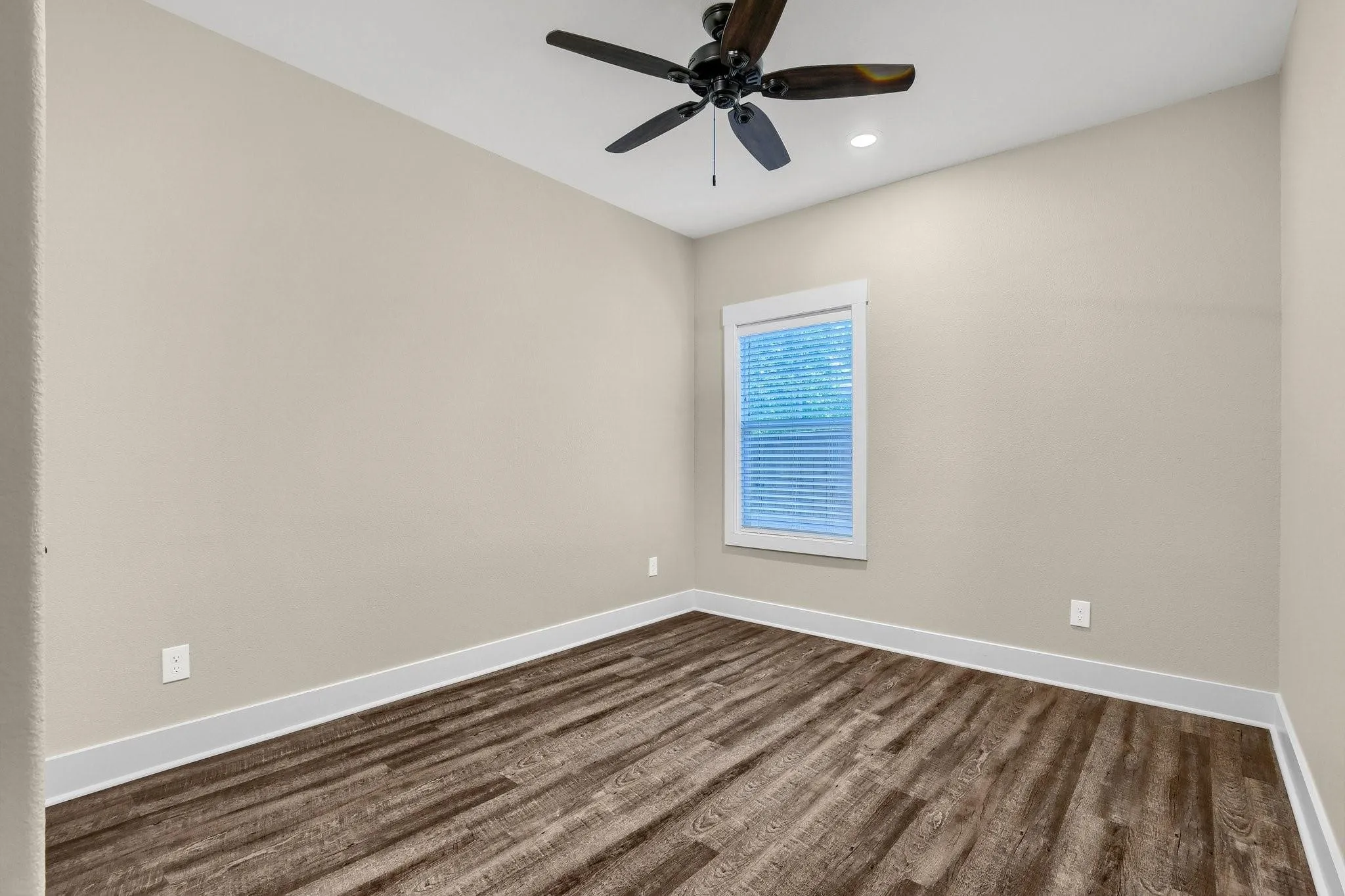 Wood-finish flooring, neutral wall tones, recessed lighting, and a ceiling fan