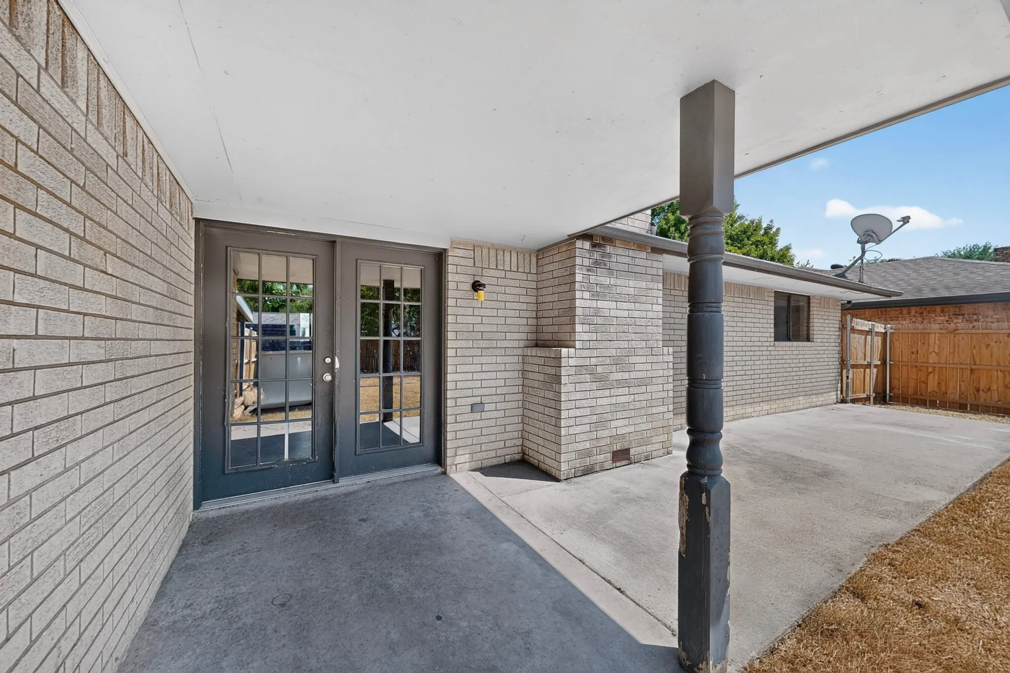 Covered patio featuring a concrete slab and brick exterior