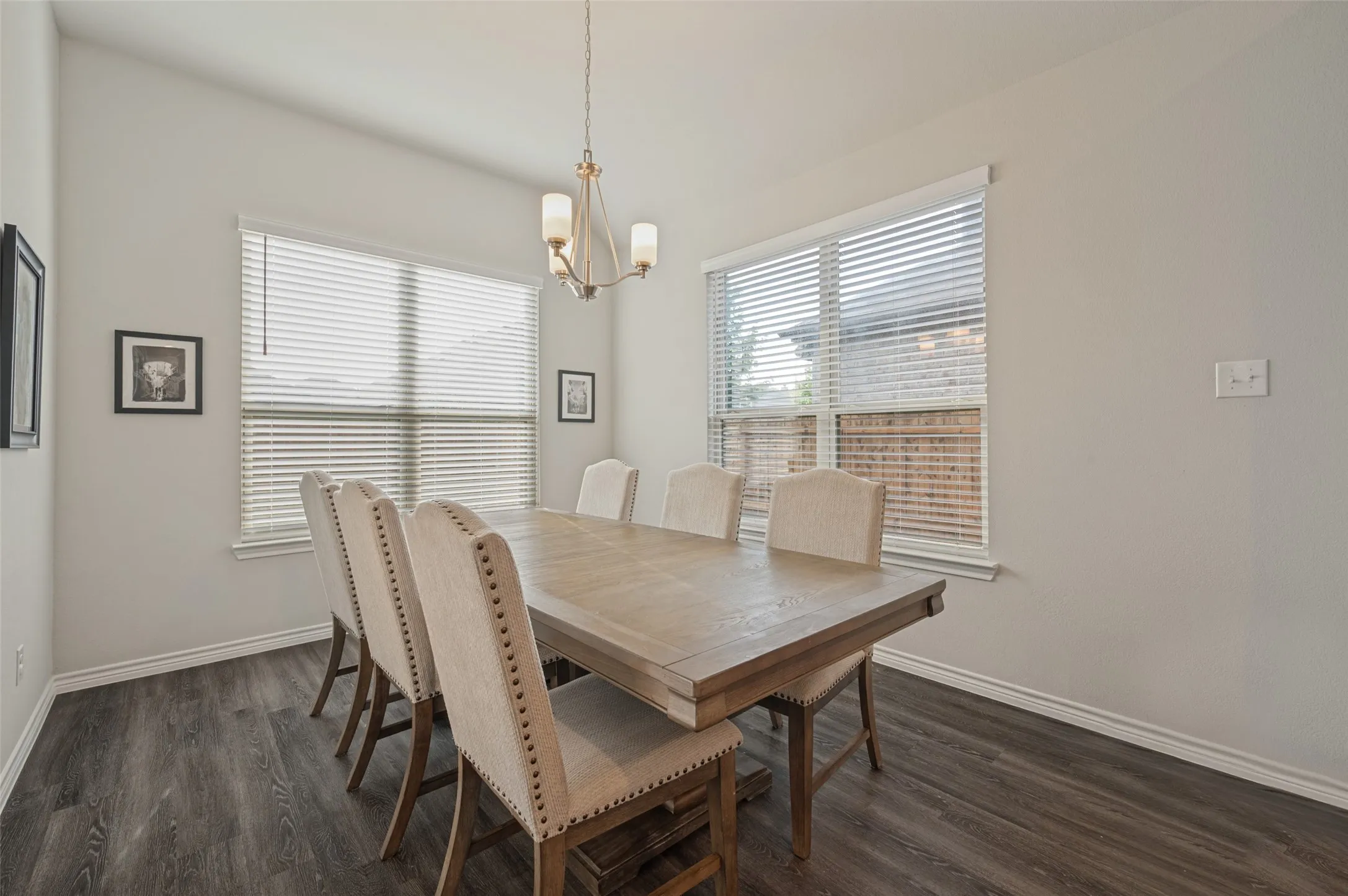 Interior space featuring wood-finish flooring, light-toned walls, and a multi-bulb chandelier