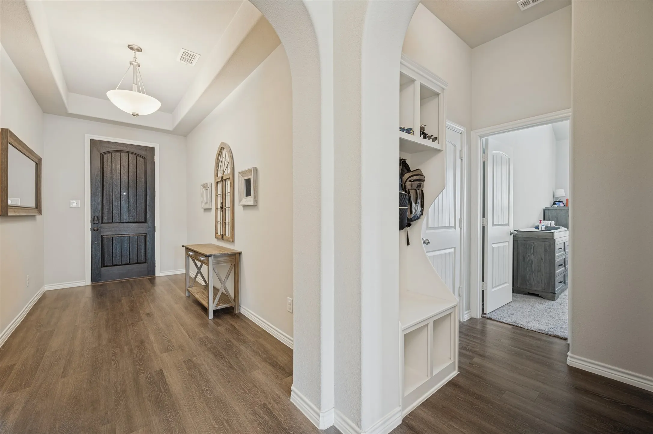Wide Entryway featuring dark wood-finish flooring and Mud Room around the corner