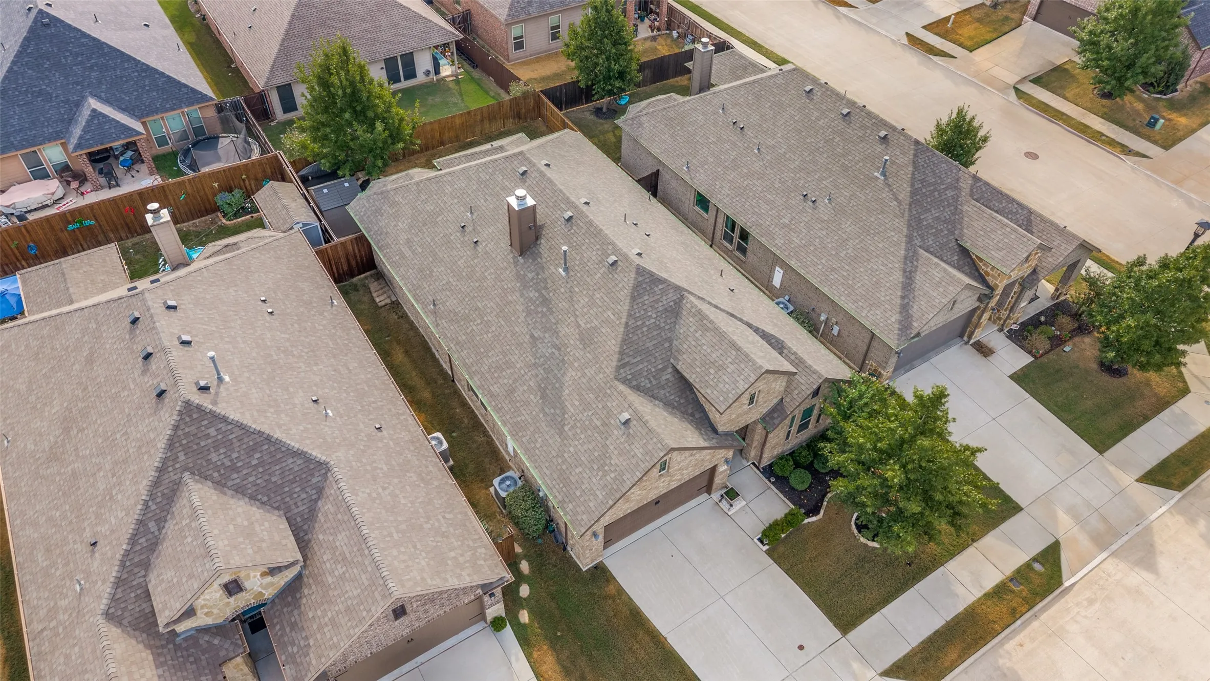 Gable roofline, attached garage, concrete driveway, landscaped front yard, and a fenced backyard
