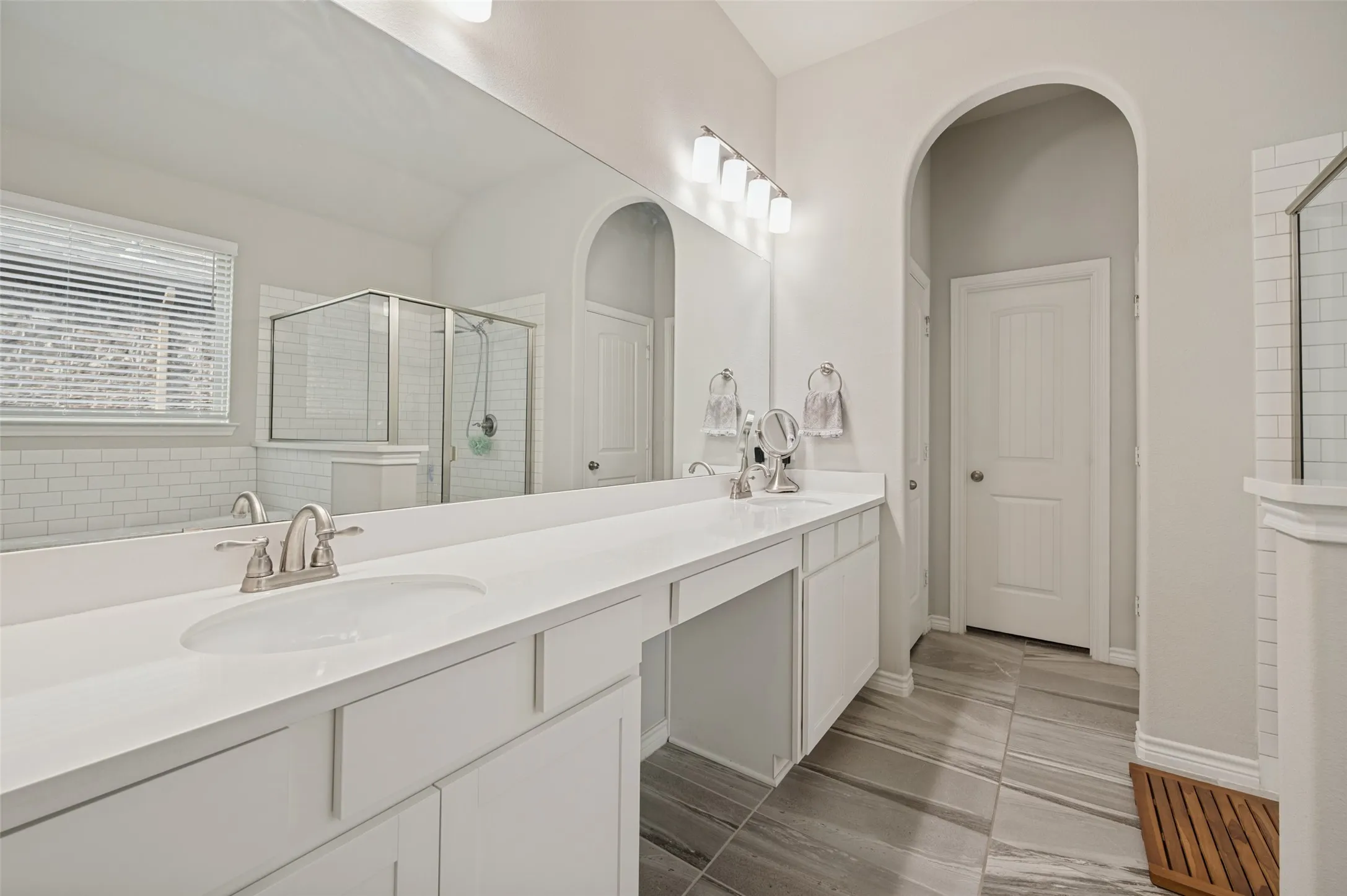 Dual vanity with white countertops, undermount sinks, and brushed nickel fixtures
